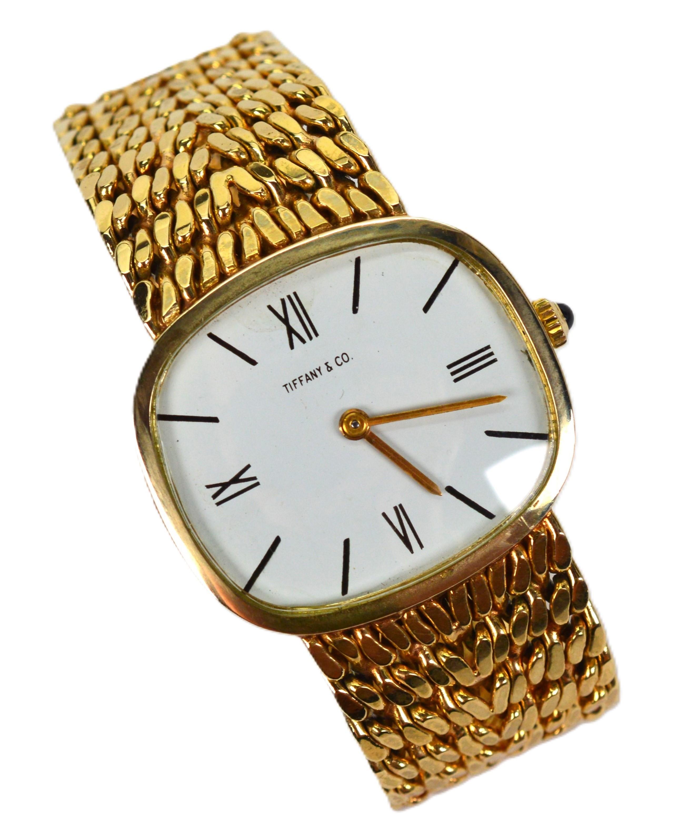 Un auténtico clásico, este reloj de mujer de alta calidad de Tiffany & Co. muestra una elegante pulsera de oro amarillo de 18 quilates de 3/4 de pulgada de ancho por 6-1/2 pulgadas de largo con dos posiciones de clip ajustables. Reloj mecánico suizo