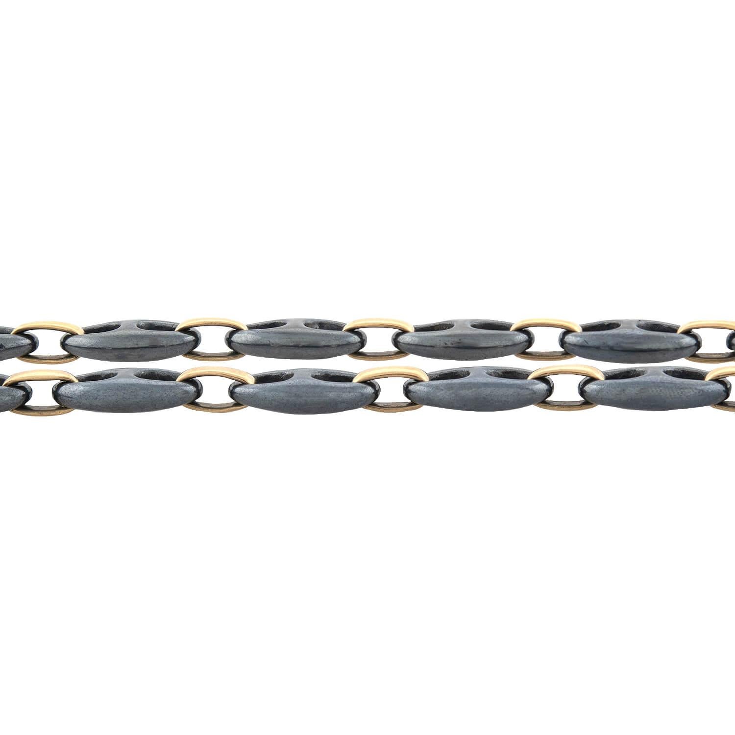 An exceptional necklace from famed maker Tiffany & Co.! Connected by 18kt yellow gold oval-shaped links, this necklace displays hand-carved hematite mariner links. The polished hematite exhibits a luxurious metallic black hue that looks gorgeous