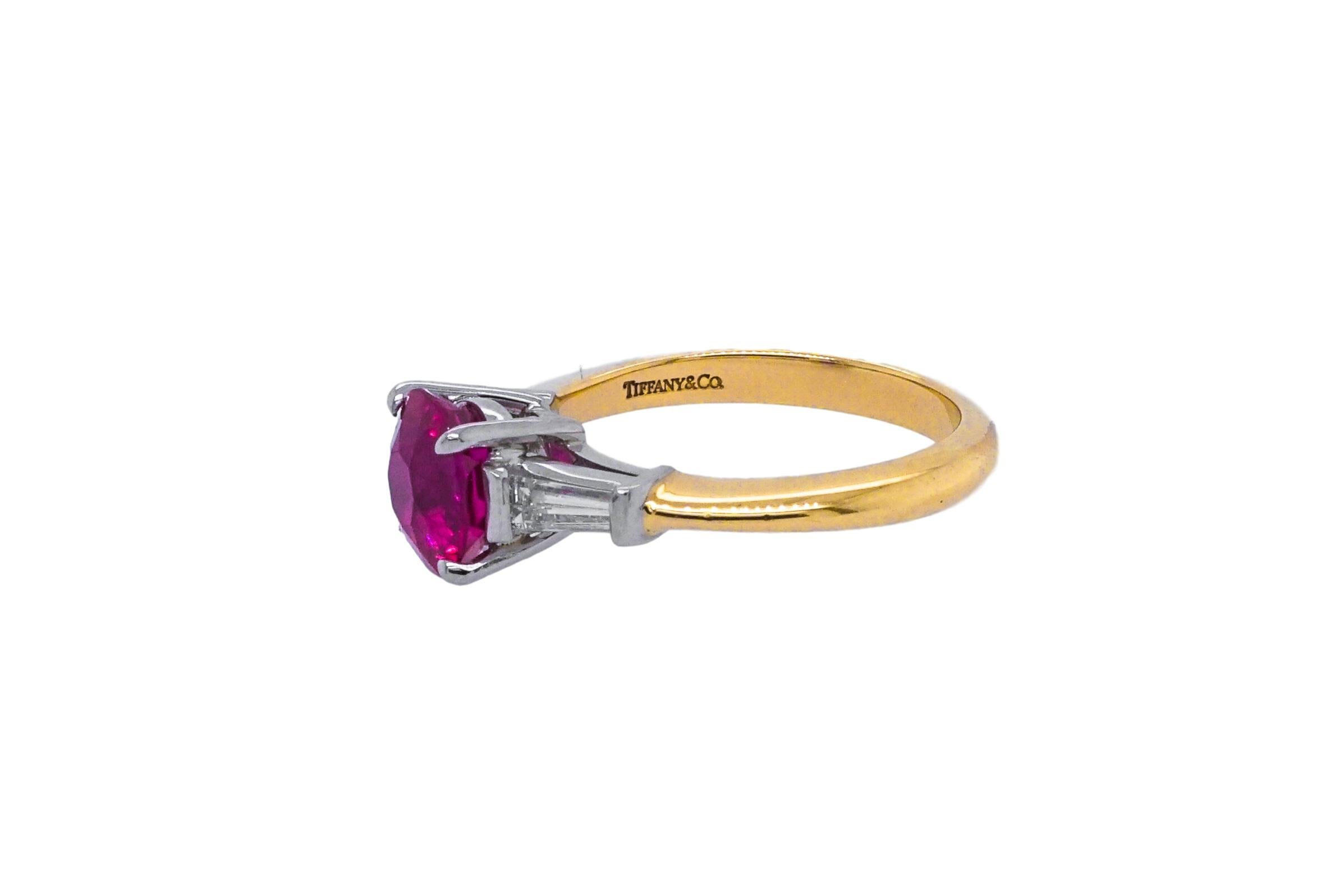 This 18kt Tiffany & Co Ring., features a single centering oval ruby approximating at 1.77 cts., this ruby is flanked by 2 tapered baguette diamonds, signed Tiffany & Co. Size 6.