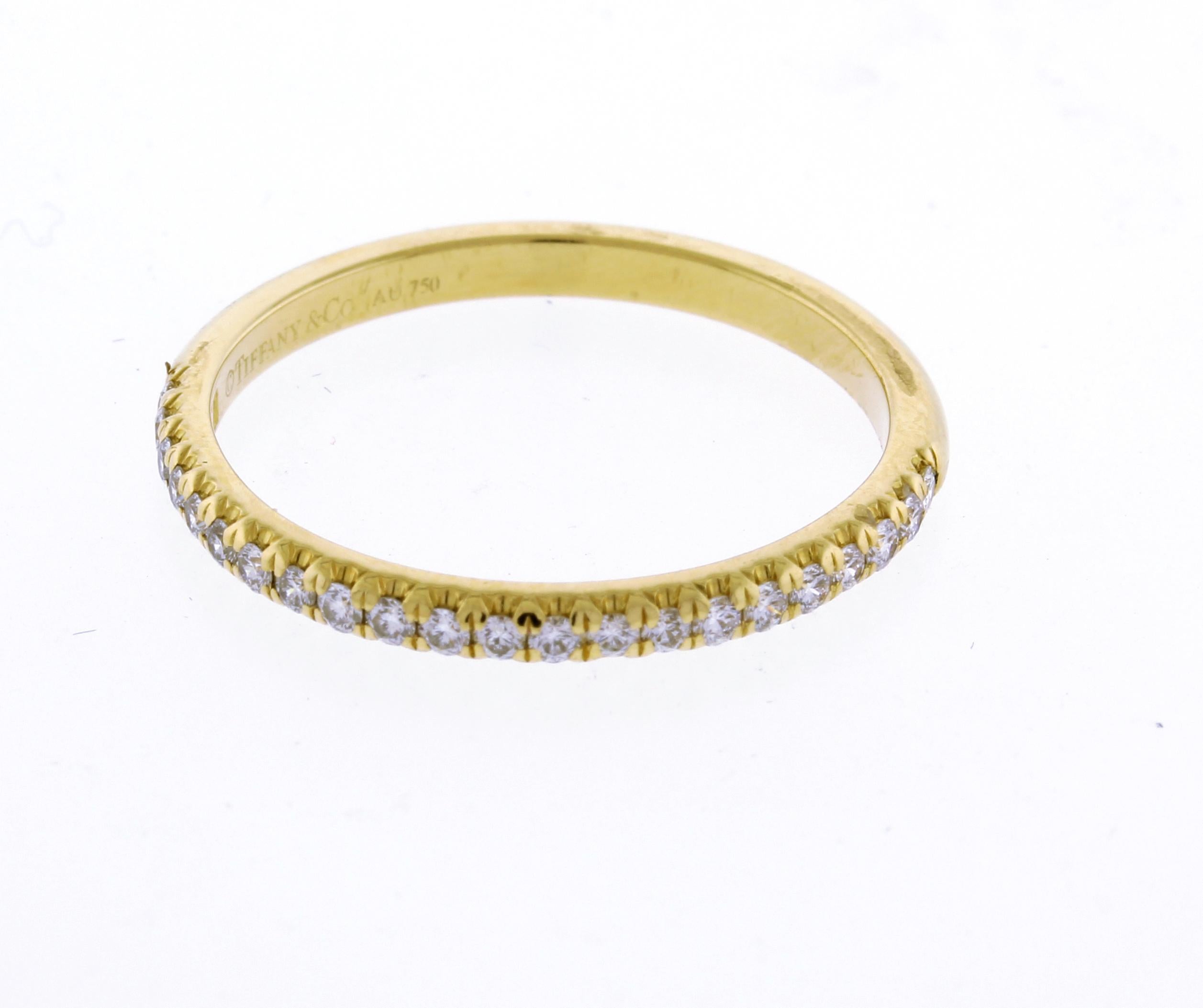 Indulge in pure luxury with Tiffany & Co.'s 18kt Yellow Gold Soleste Band. This exquisite ring features a sparkling Soleste half way around band with 22 diamonds, totaling .17cts. Treat yourself or a loved one to this stunning size 7 ring.