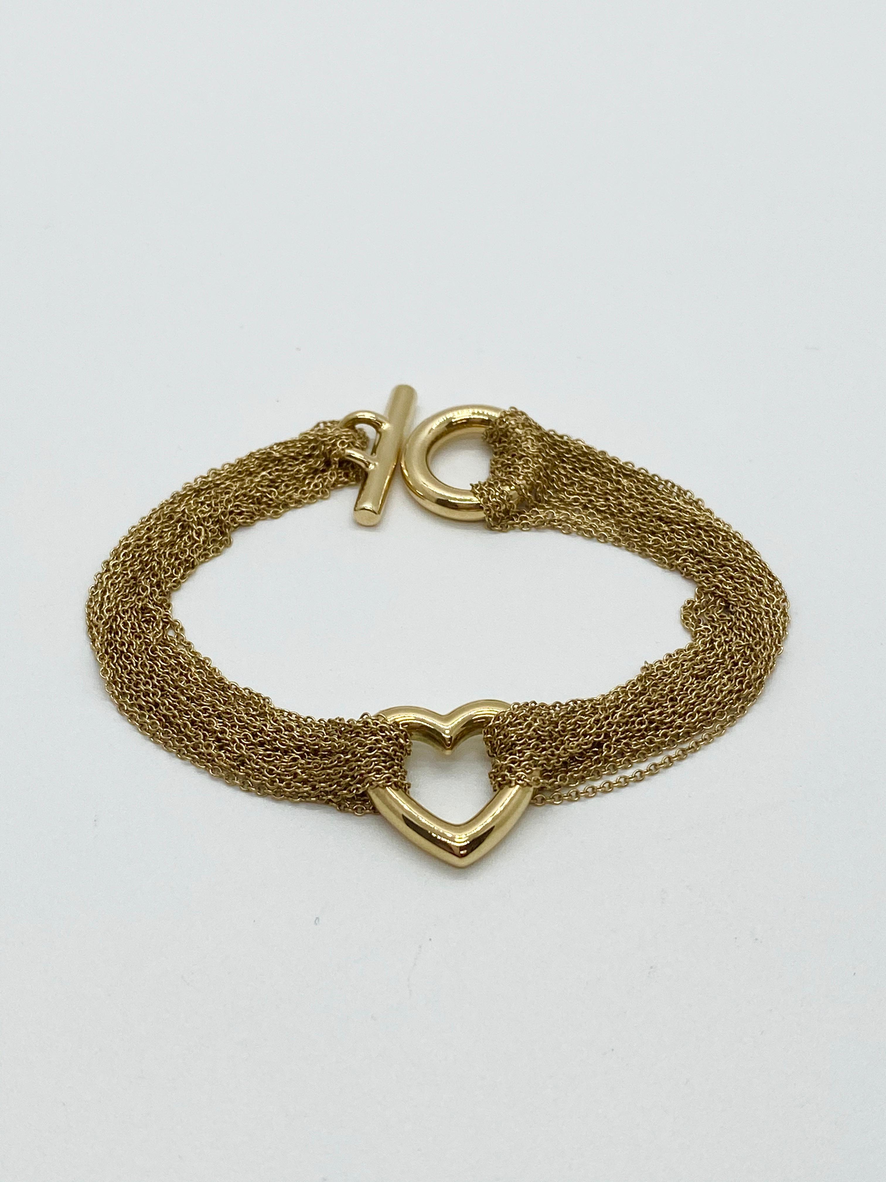 Vintage Tiffany & Co 18k yellow gold heart mesh bracelet.  Bracelet consists of multi strands of cable link chain in 18k yellow gold with 1.25 inch heart charm.  Bracelet length is 7 inches and has a toggle clasp.  