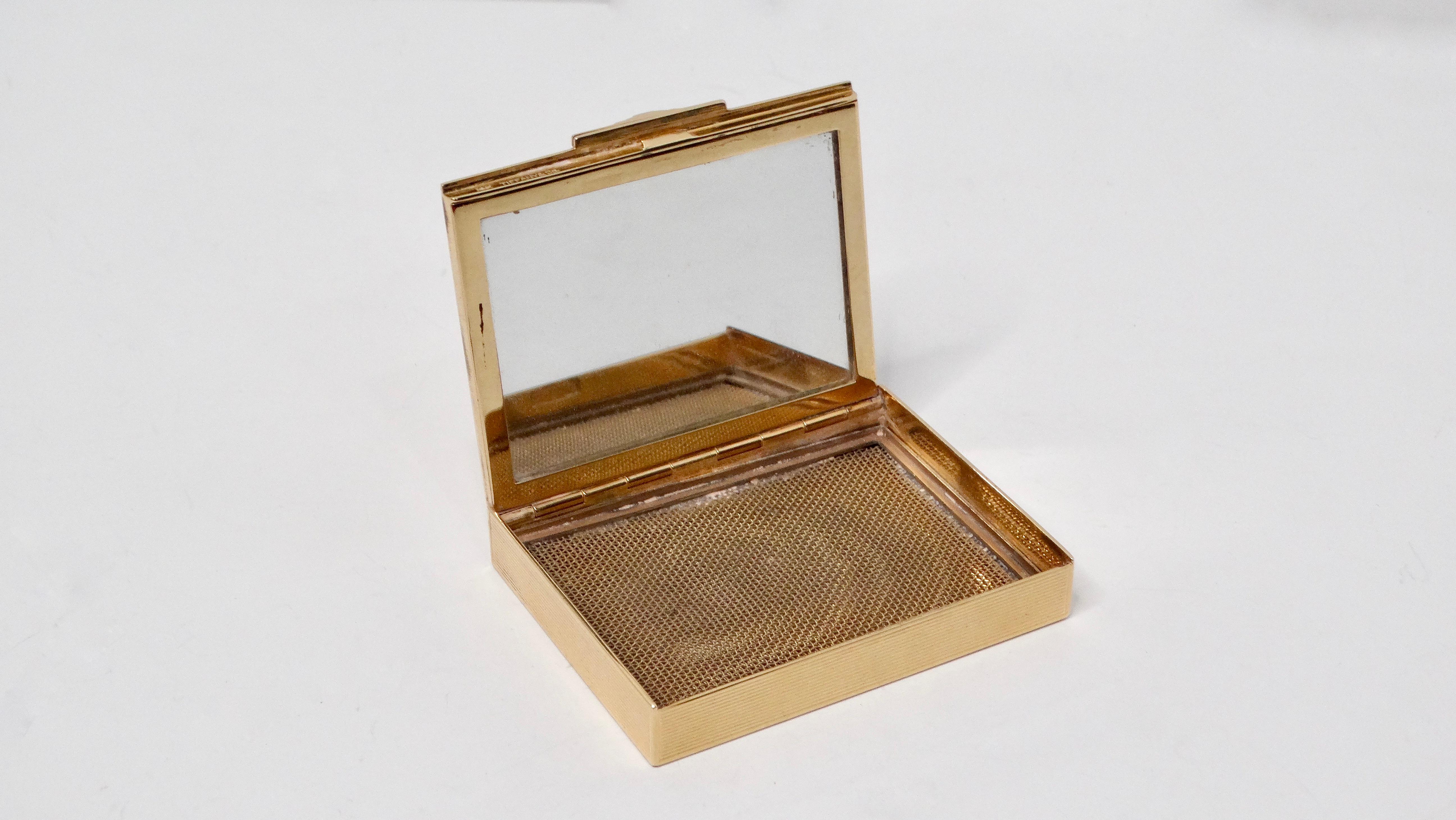 Esta exquisita caja para espejo compacto de Tiffany & Co., de la década de 1940, es una impresionante representación de la elegancia y la artesanía vintage. Fabricada en oro de 14 quilates, la superficie presenta delicadas líneas grabadas que captan