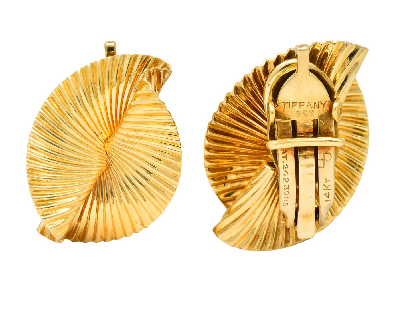 Each designed as a torqued foliate motif

With a polished ribbed texture

Completed by hinged ear clip-backs

Fully signed Tiffany & Co. and stamped 14KT for 14 karat gold

Circa 1950's

Measures: 7/8 x 11/16 inch

Total weight: 9.0 grams

Dynamic.