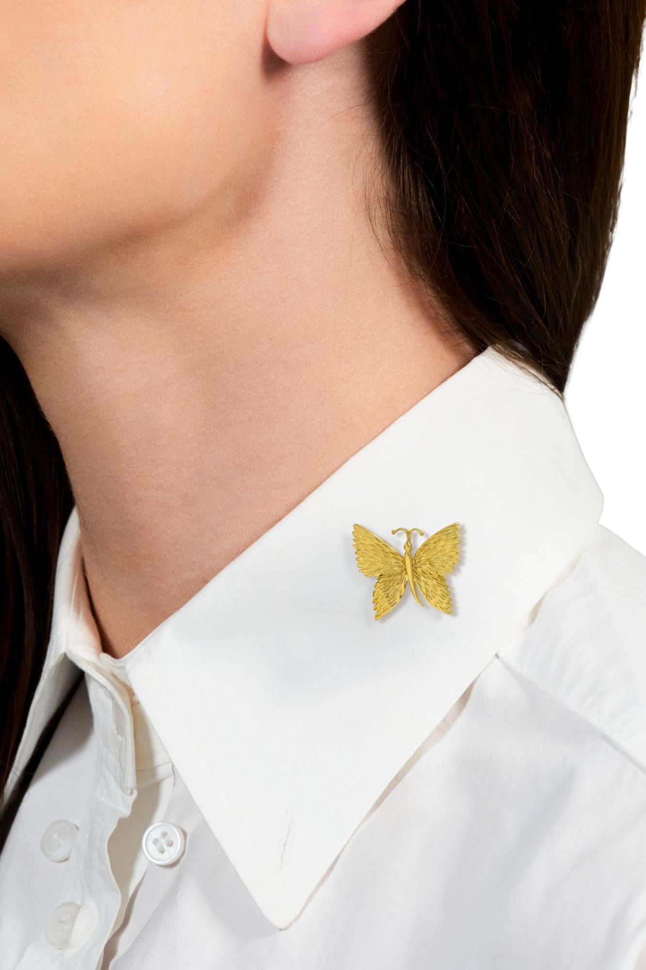 Designed as a stylized butterfly with dimensional wings, curling antennae, and curving body
Accented by deeply grooved texture throughout wings
With high polish finish body and antennae
Completed by hinged pinstem with locking closure
Stamped for 18