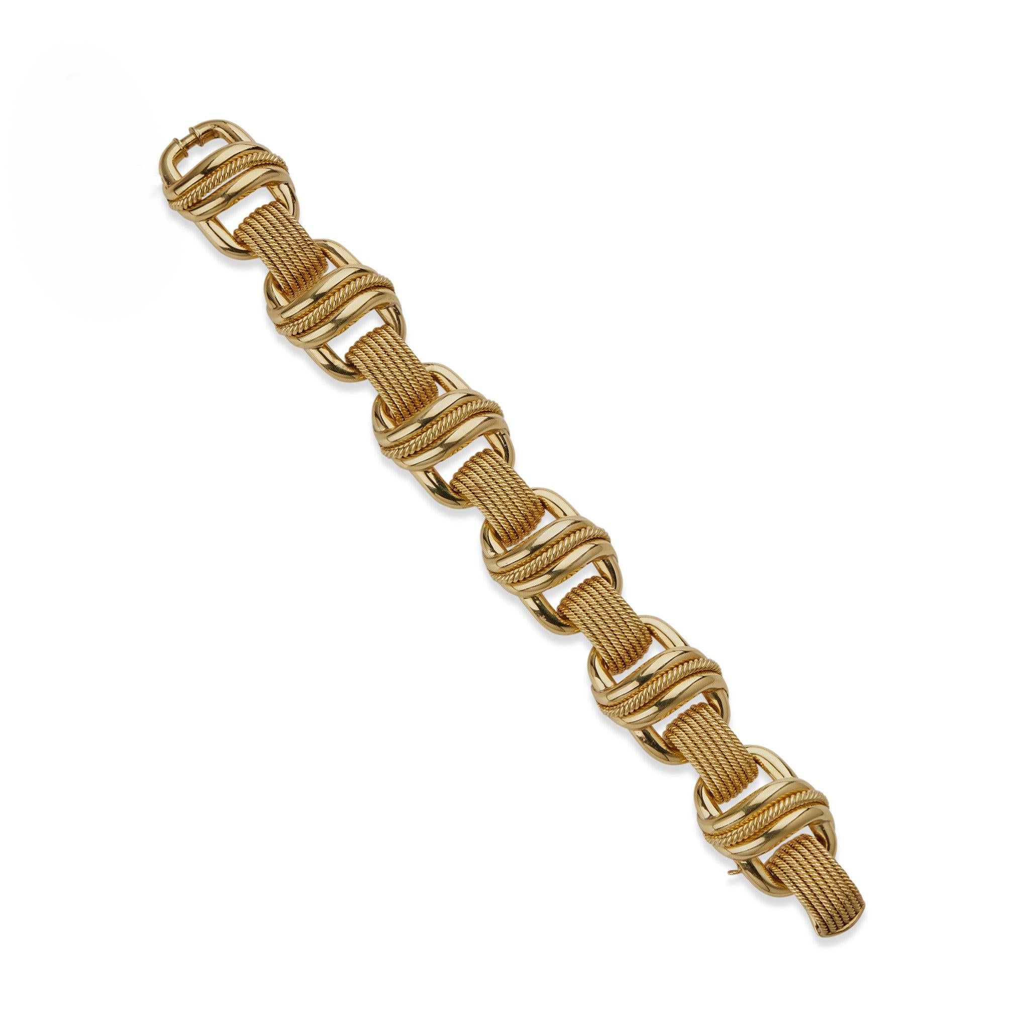 Dieses Armband aus 18 Karat Gold wurde in Italien für Tiffany & Co. hergestellt und stammt aus den 1960er Jahren. Es besteht aus einer Reihe von ovalen, gewölbten Bombengliedern mit geschwungenen Motiven und Akzenten aus Seidengeflecht, die durch