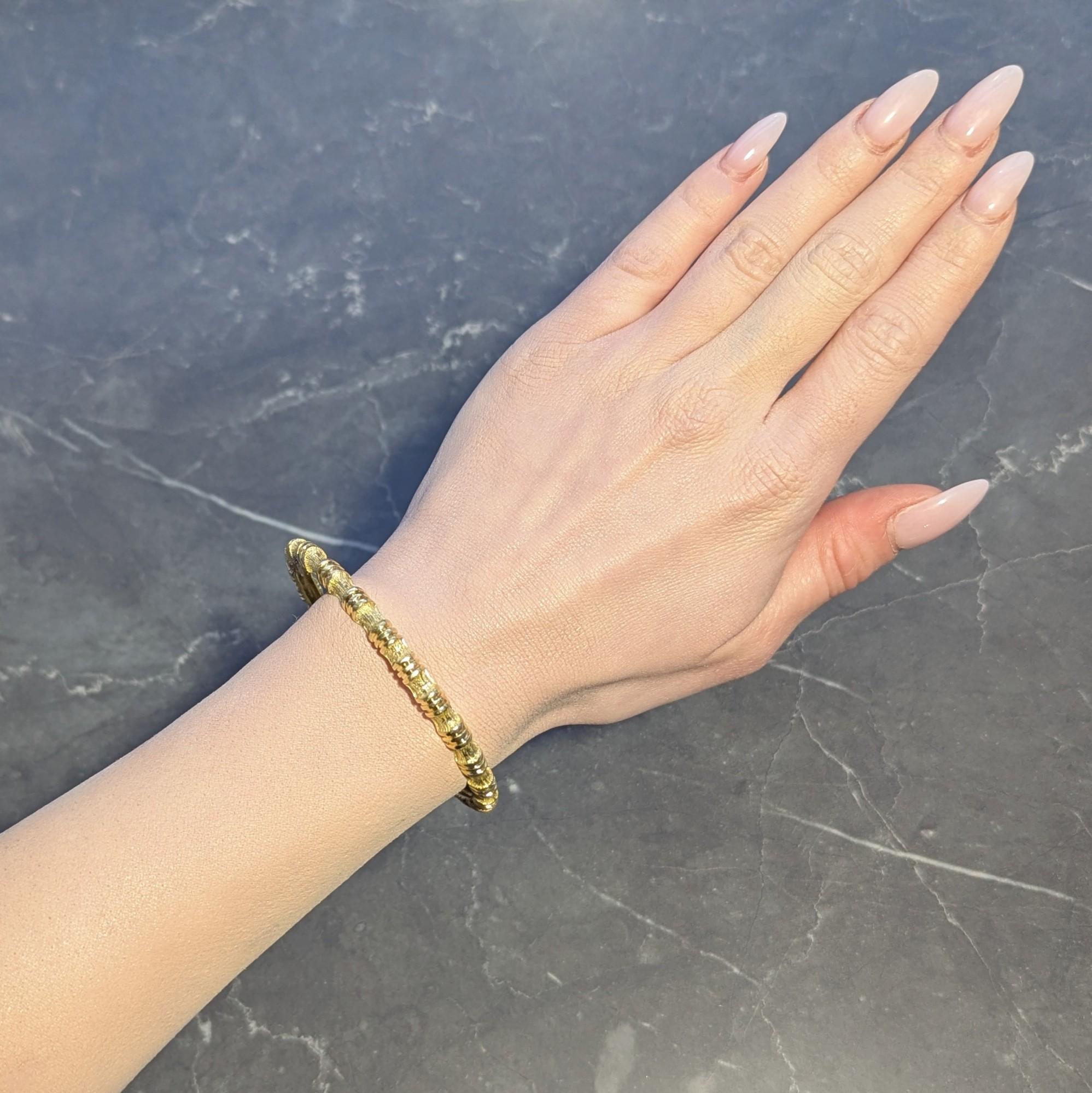 Oval shaped bangle is designed with a bamboo motif fully around
Comprised of fluted segments and engraved texture
With high polish finish on fluted segments
Stamped for 18 karat gold
Fully signed for Tiffany & Co.
Circa: 1970s
Width at Widest: 1/4