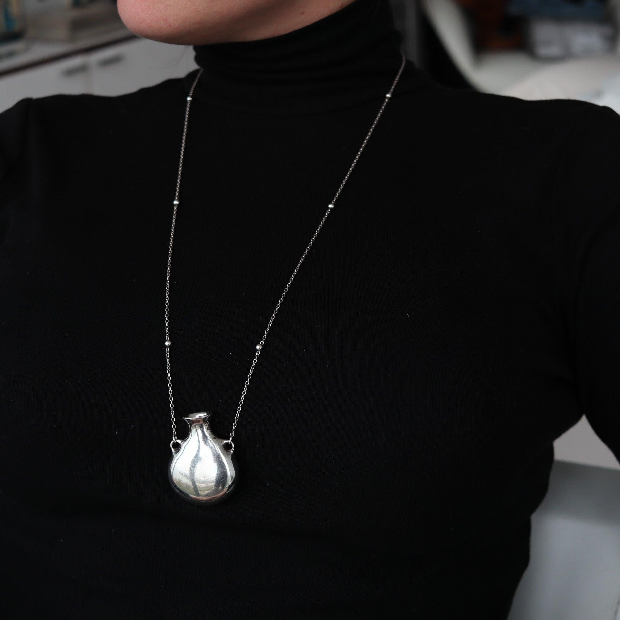 Open bottle necklace designed by Elsa Peretti (1940-2019) for Tiffany & Co.

This is a gorgeous freeform open bottle created by Elsa Peretti for Tiffany & Co. back in 1977. The iconic vintage pendant necklace has been crafted in the purest plain