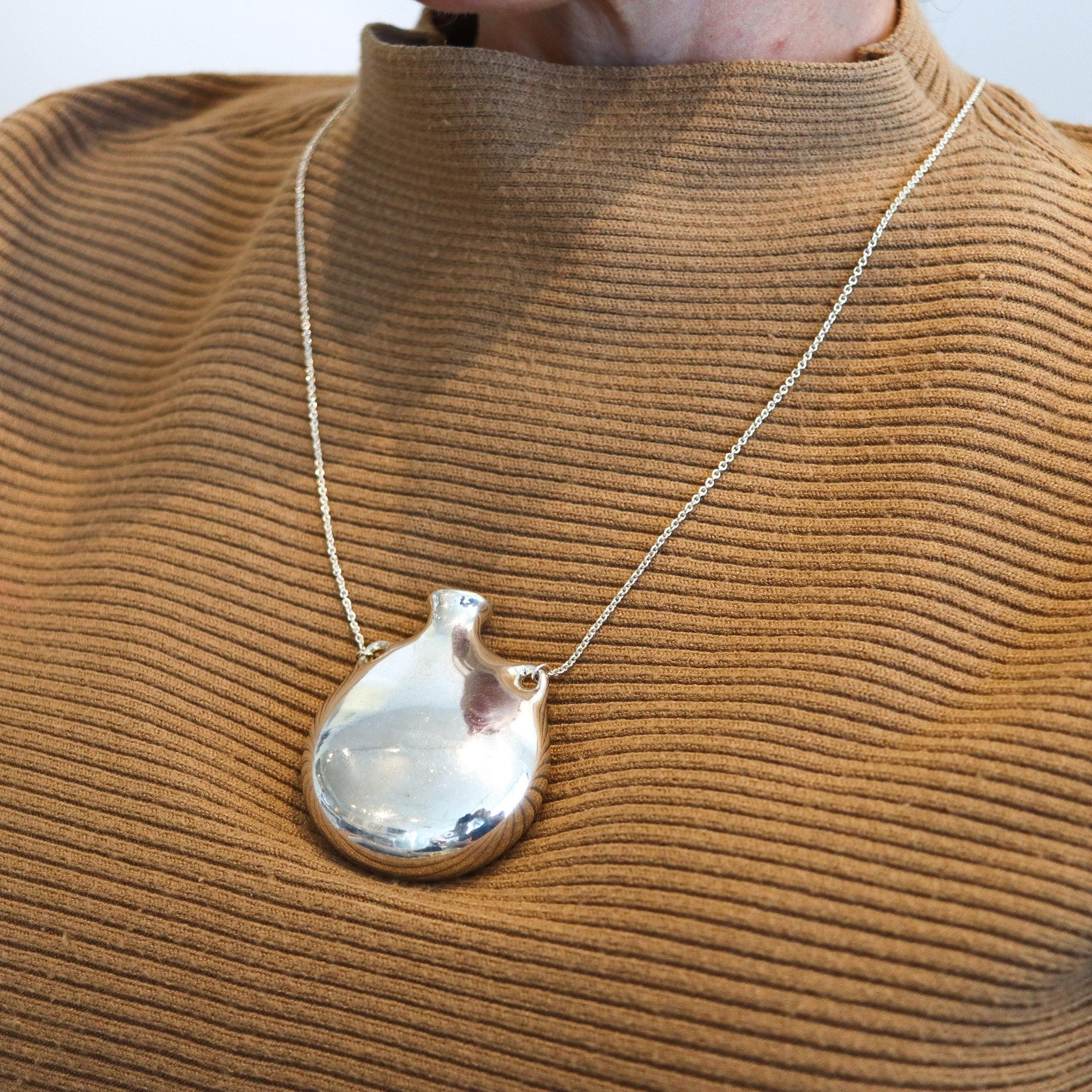 Bottle necklace designed by Elsa Peretti (1940-2019) for Tiffany & Co.

This fabulous freeform open jar-bottle was created by Elsa Peretti for Tiffany & Co. back in the 1978. This iconic vintage pendant necklace has been crafted in the purest plain