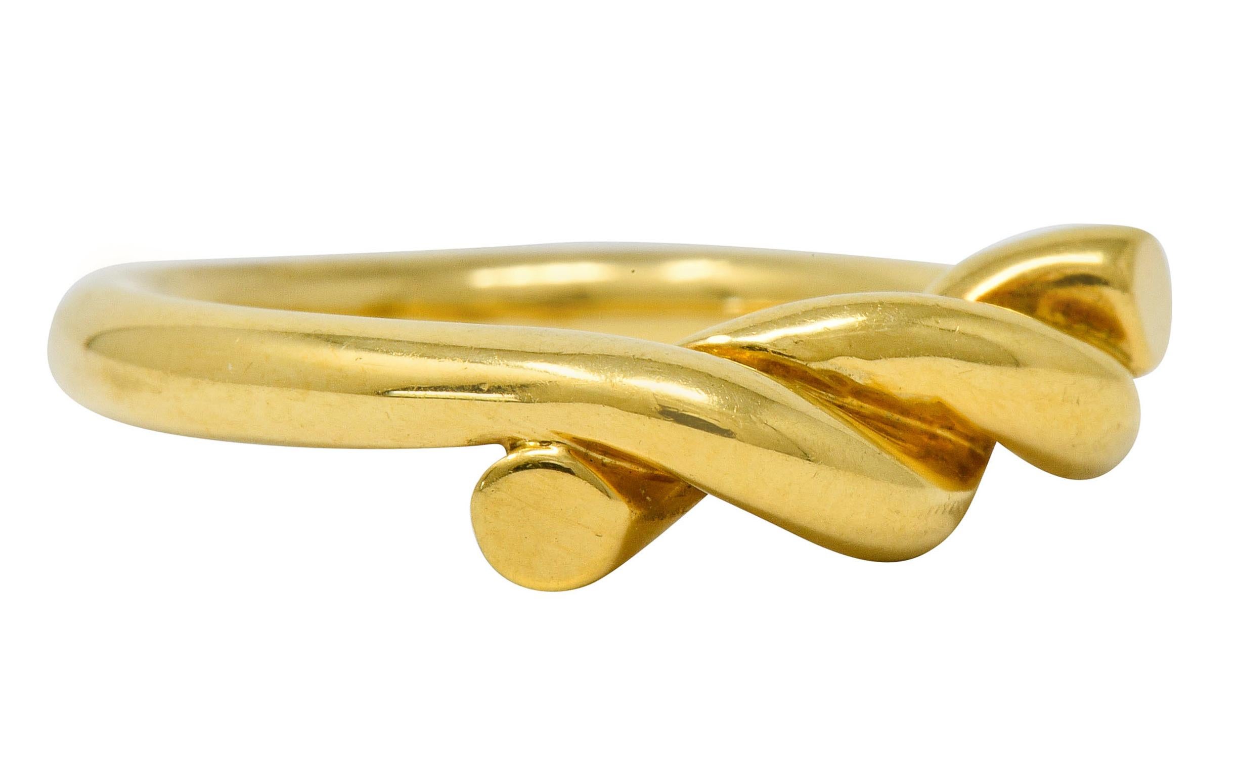 Band ring designed as a rope that twists together, cinching center as a knot

Featuring a bright polish

Fully signed Tiffany & Co.

Stamped 18K for 18 karat gold

Circa: 1980s

Ring Size: 6 1/4 & sizable

Measures: 5.4 mm wide and sits 5.0 mm