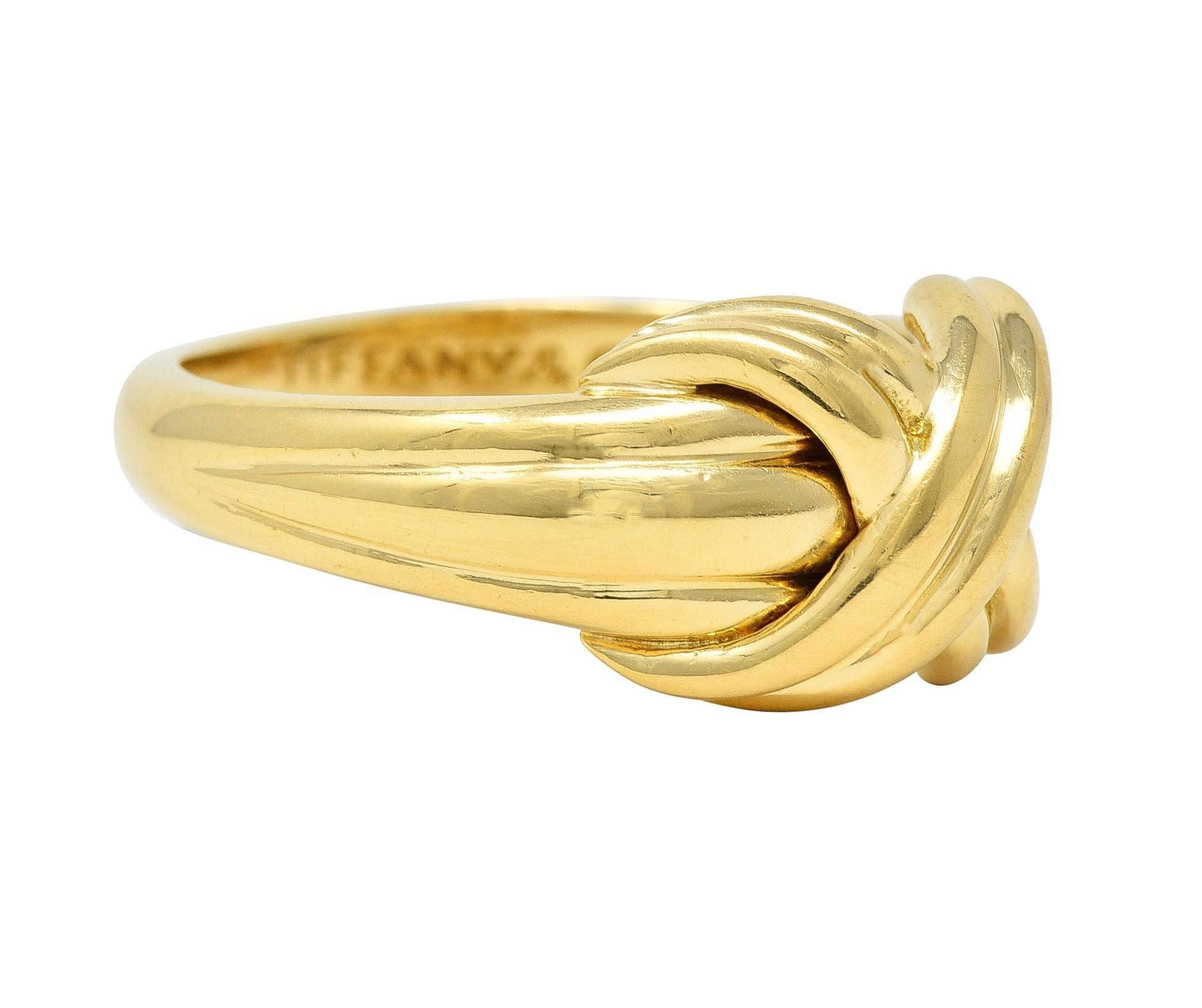 Designed as a tied fabric knot with grooved detail
Centering an 'X' motif 
With high polish finish 
Stamped for 18 karat gold 
Fully signed Tiffany & Co.
Circa: 1990; via dated inscription 
Ring size: 5 1/2 and not sizable 
Measures north to south