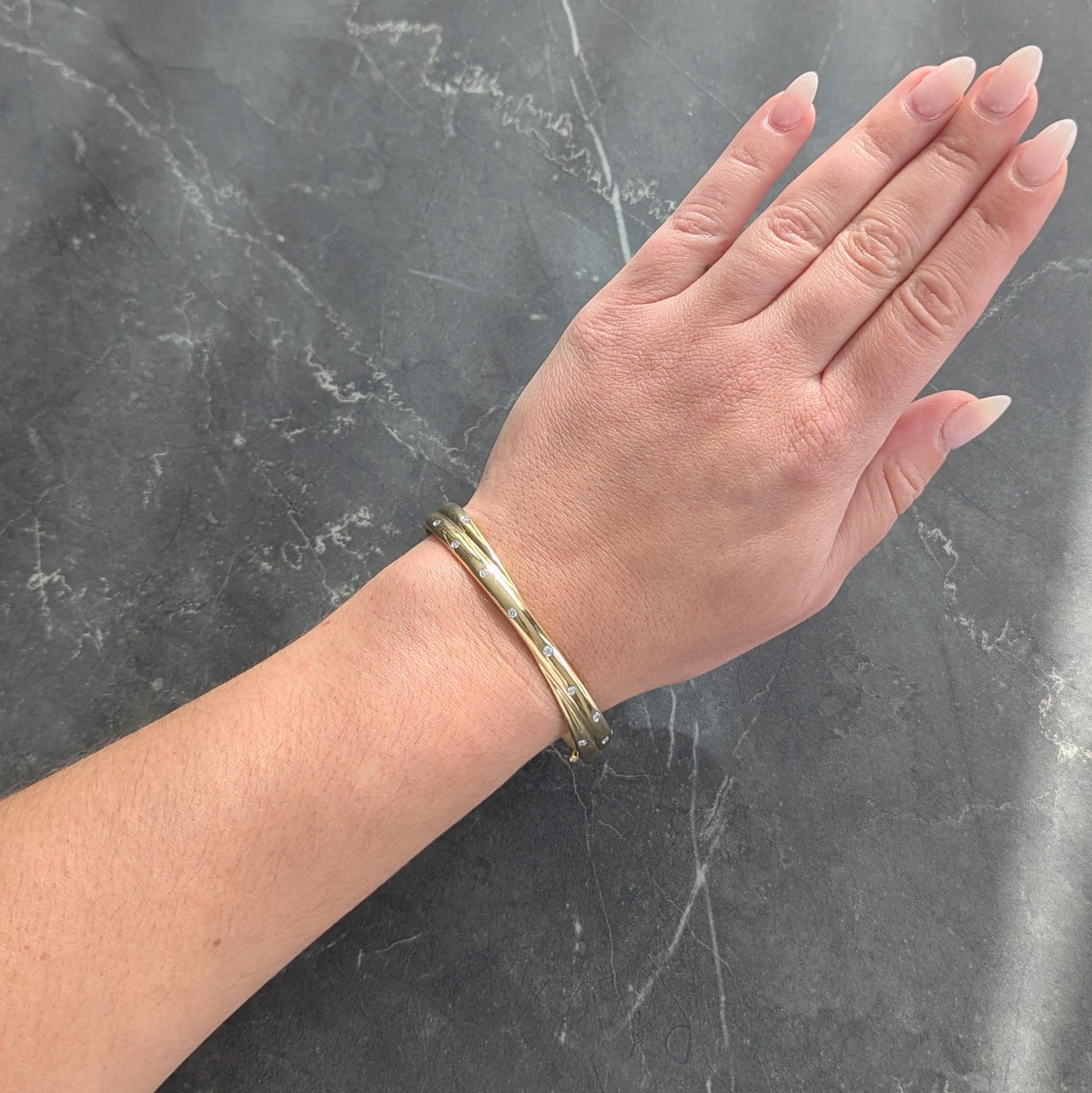 Oval shaped bangle is designed as two overlapping gold bands
Flush set with round brilliant cut diamonds in platinum
Weighing approximately 0.50 carat total - G color with VS2 clarity
Opens on a hinge via press release clasp
With hinged bar