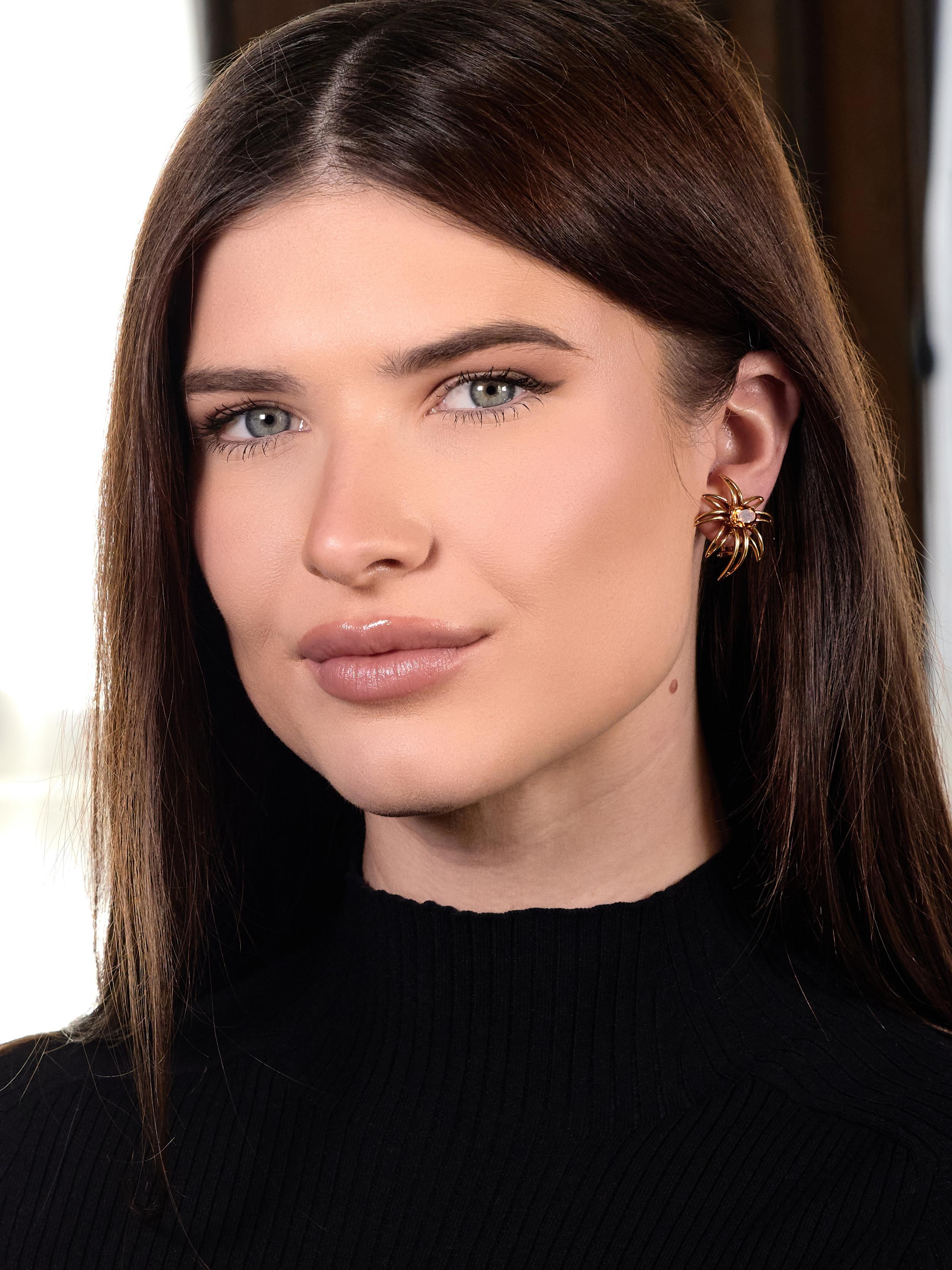 Designed as a stylized firework burst comprised of pierced linear gold
Centering oval cut citrines weighing approximately 2.12 carats total
Transparent medium brownish orange and prong set in baskets
Featuring a high polished finish