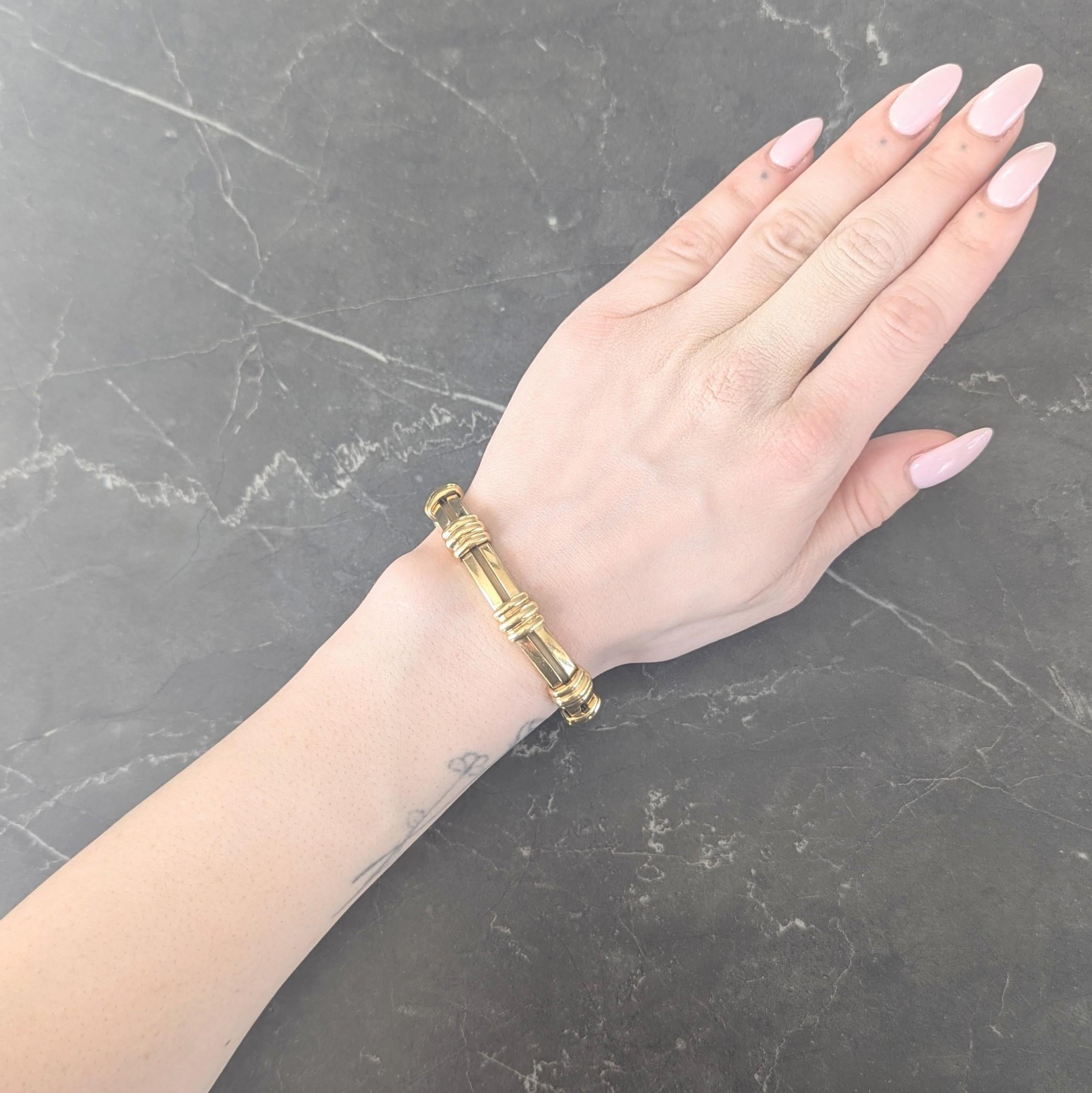 Comprised of hinged elongated bar links with short terminals
Grooved and fluted to depict a roman column motif
With a high polish finish throughout
Completed by concealed clasp closure
With a hinged figure eight safety
Stamped for 18 karat