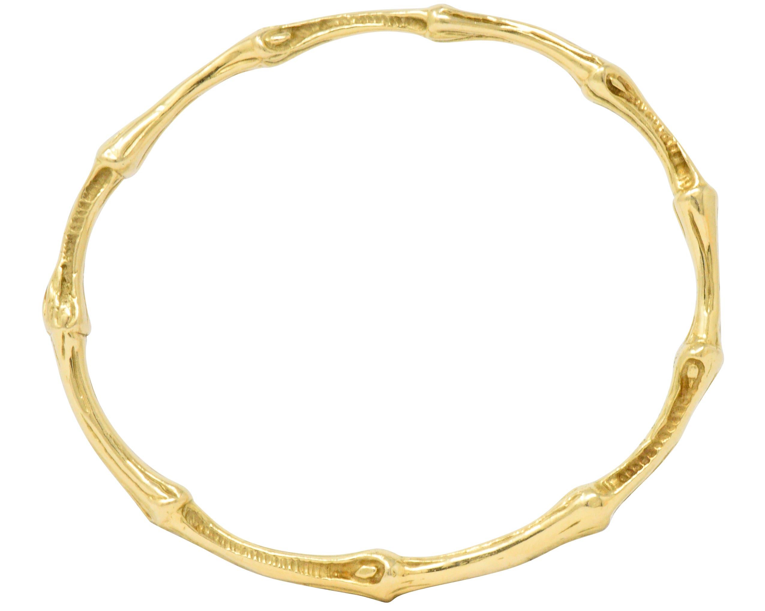 Slip-on style bangle

Bamboo motif with textured and polished gold

Fully signed Tiffany & Co., stamped 1996 and 750 for 18 karat gold

Inner Circumference: 7 1/4 Inches

Width: 1/4 Inch (widest)

Total Weight: 33.1 Grams

Exotic. Fashionable.