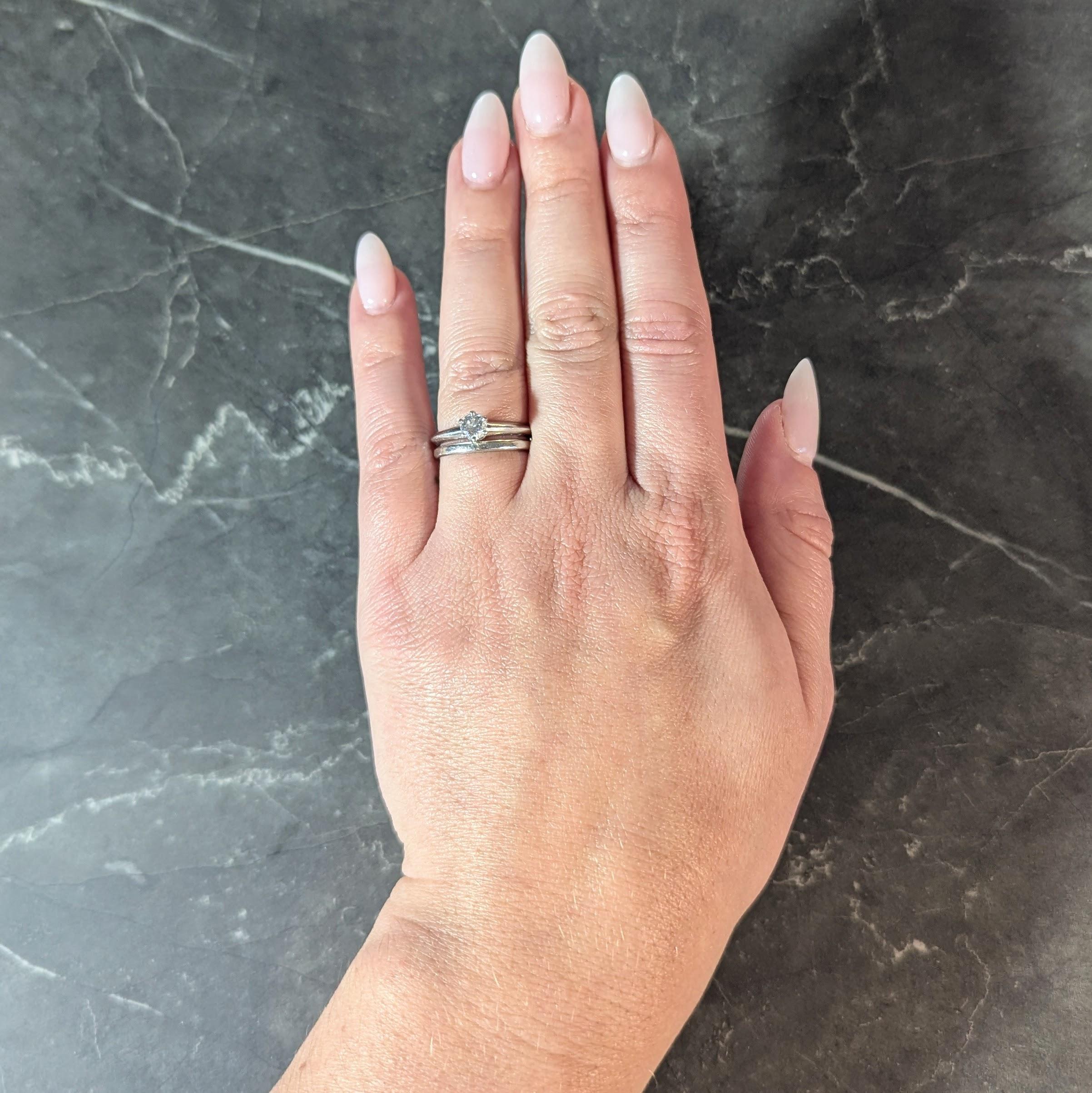 Comprised of a matching solitaire engagement ring and wedding band set
Engagement ring centers a prong set round brilliant cut diamond
Weighing 0.39 carat total - H color with VS1 clarity
Completed by subtle knife edge shank
Wedding band is slightly