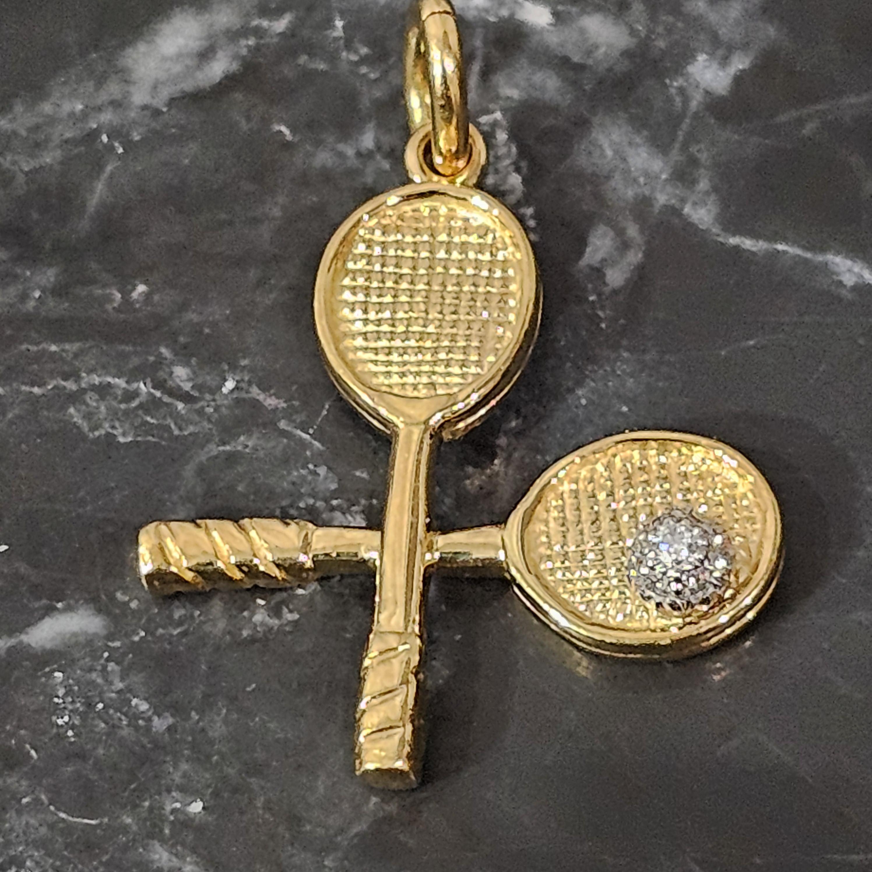 Tiffany & Co. Tennis Racket Pendant 18k Gold Diamond.

This exquisite pendant by Tiffany & Co. showcases a charming tennis racket design, crafted in luxurious 18k yellow gold.

The piece features round white diamonds, weighing 0.07 carats, elegantly