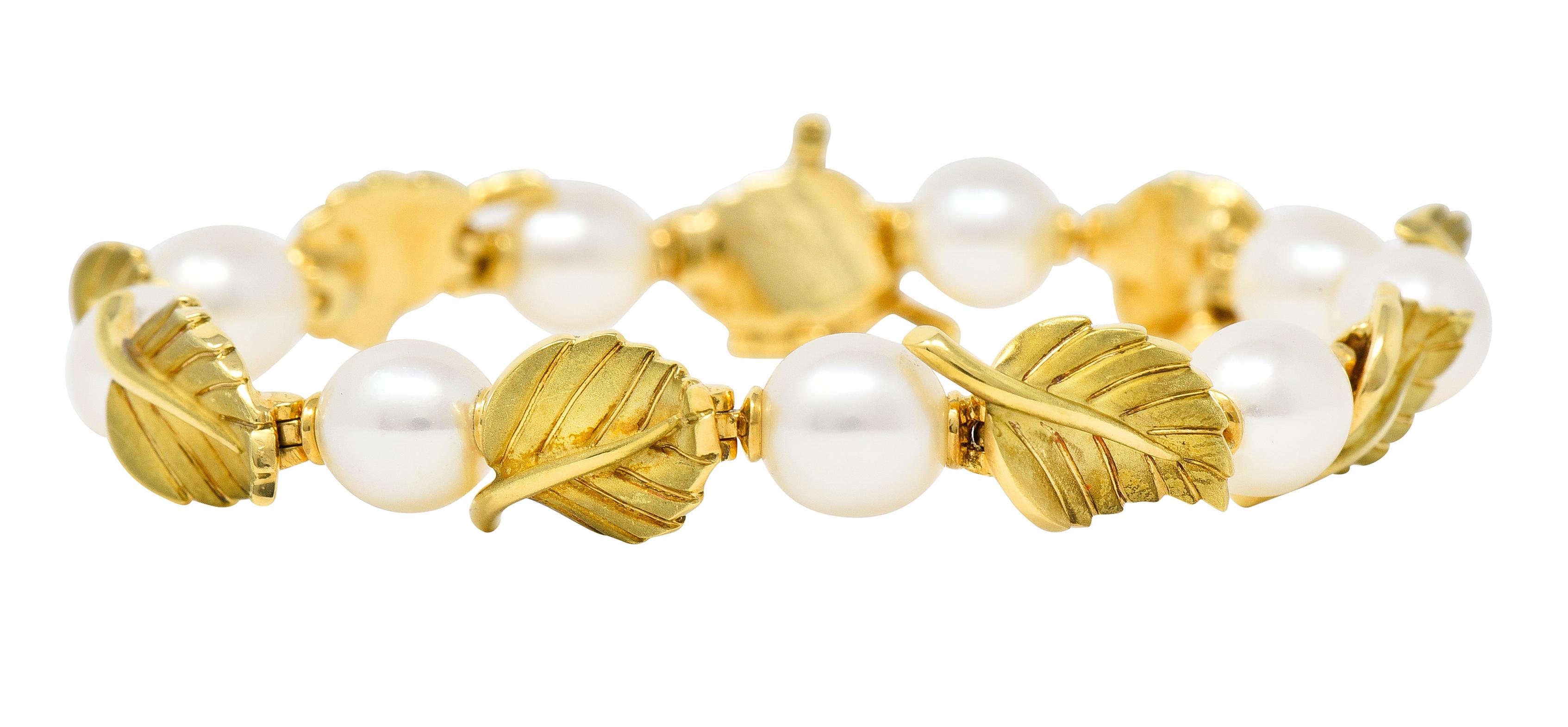 Mit 7,0 mm großen, fast runden Zuchtperlen - weiß mit leichtem Schimmer. Abwechselnd mit aufklappbaren Gliedern mit Blattgoldmotiven - matt mit eingravierten Adern. Dimensional mit einrollenden Kanten und erhöhten Stielen. Mit verdeckter Schließe.