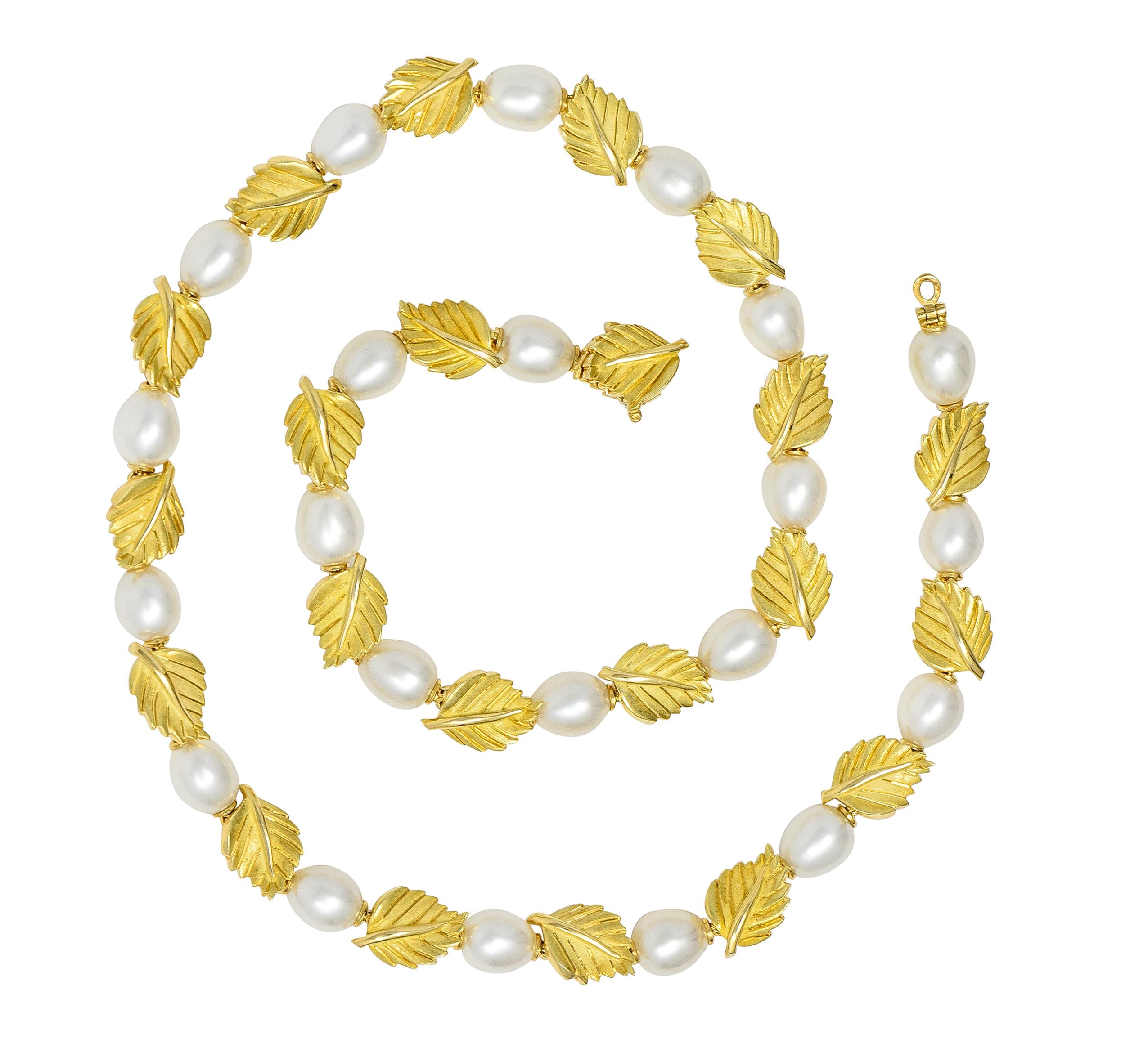 Featuring 7.0 mm near-round cultured pearl beads - white with moderate iridescence. Alternating with hinged gold leaf motif links - matte with engraved veins. Dimensional with furling edges and raised stems. Completed by concealed clasp. Stamped 750