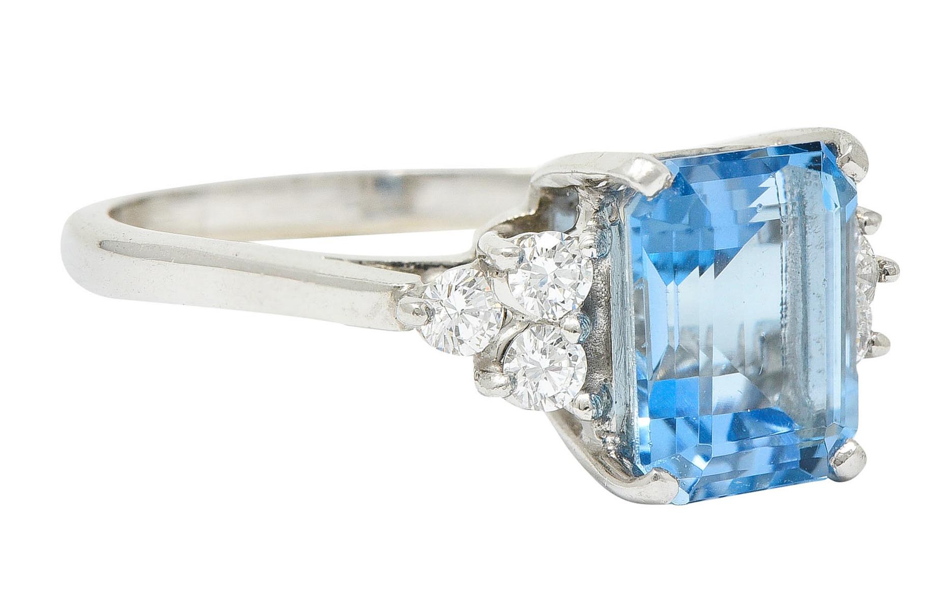 Centering an emerald cut aquamarine weighing approximately 2.15 carat

Transparent with saturated sky blue color

Basket set and flanked by triad clusters of round brilliant cut diamonds

Weighing in total approximately 0.25 carat with G/H color and