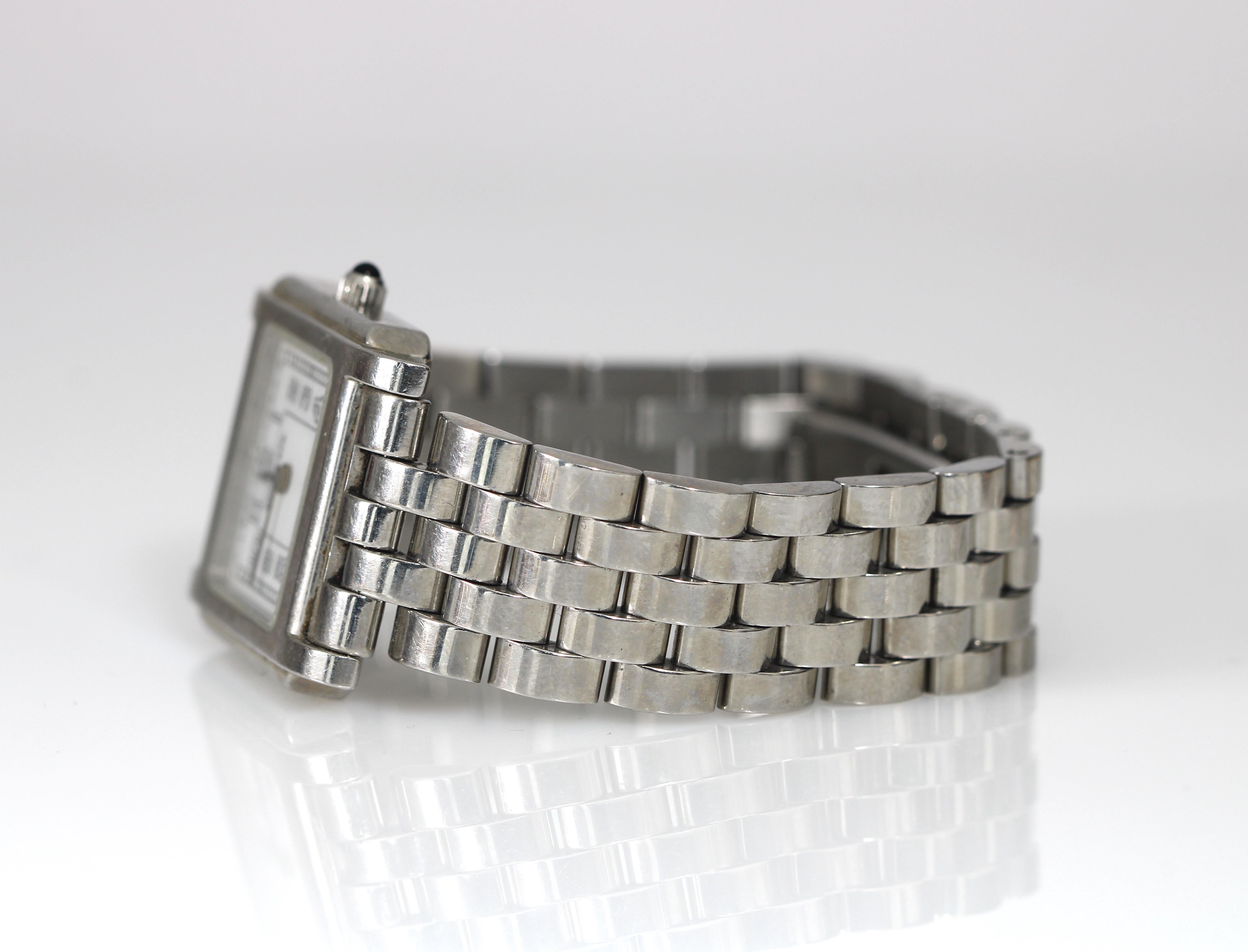 Up&Up est une montre-bracelet classique en acier inoxydable de Tiffany & Co. La montre a un boîtier de 24 mm et une finition polie. La montre convient actuellement à un poignet de 6,5 pouces et peut être réduite en enlevant des maillons. Le