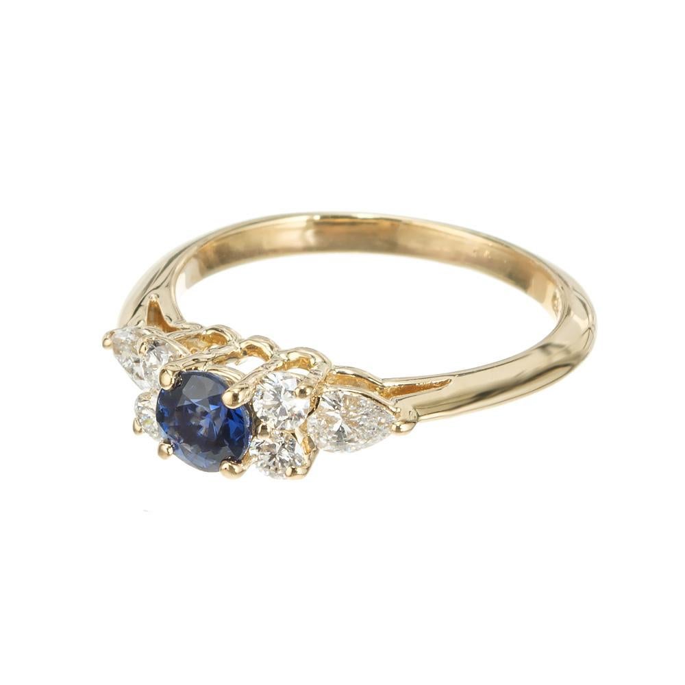Tiffany & Co. 1970's Sapphire and diamond engagement ring. Vivid blue round center sapphire set in a 18k yellow gold setting with 4 round brilliant cut diamonds and 2 accent pear shaped diamonds. Tiffany & Co. hallmark.  

1 round blue sapphire,