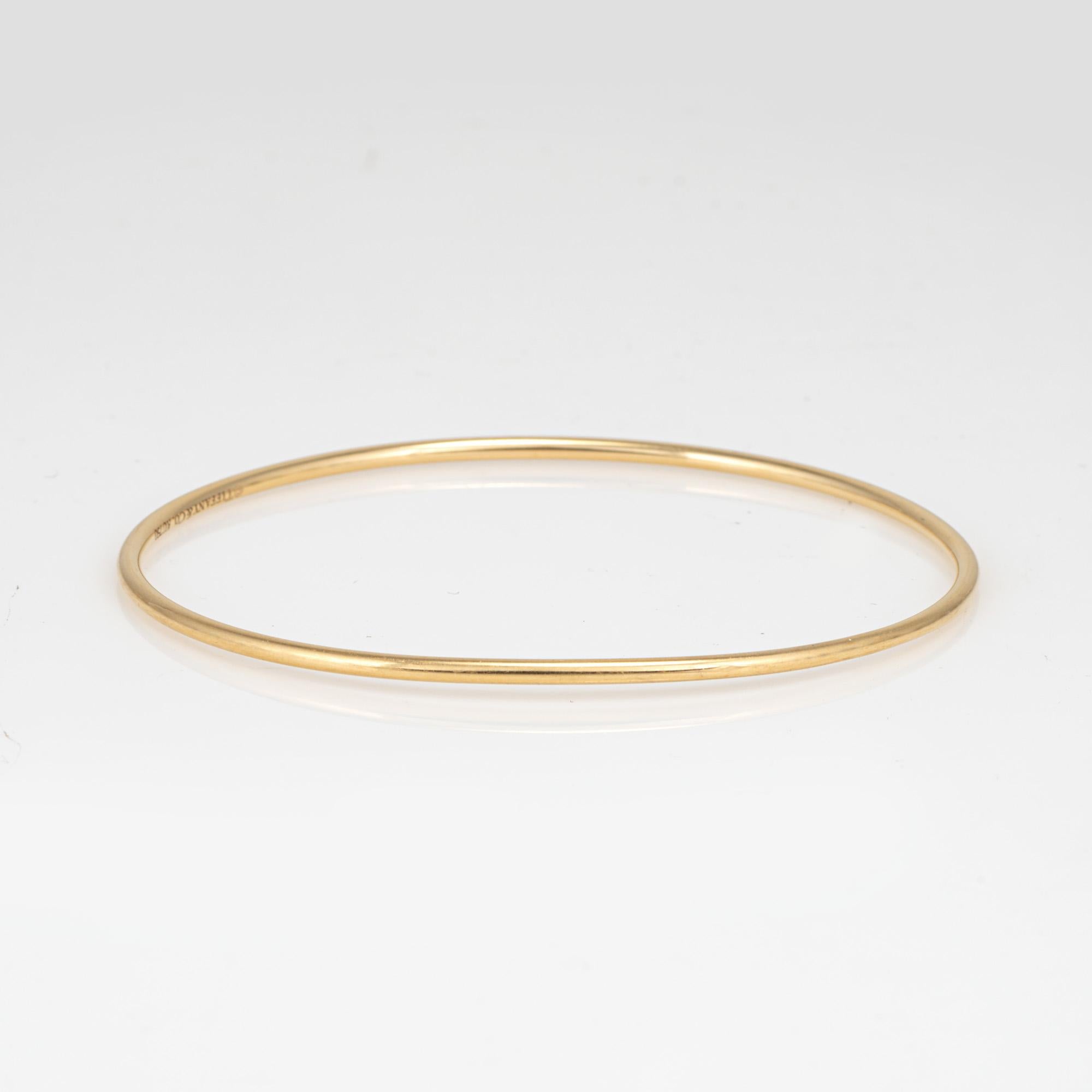 Stylish vintage pre-owned Tiffany & Co bangle bracelet crafted in 18 karat yellow gold.  

The thin 2mm wire style bangle is a classic & great worn alone or stacked. No box or papers.  

The bracelet is in very good condition and was lightly cleaned