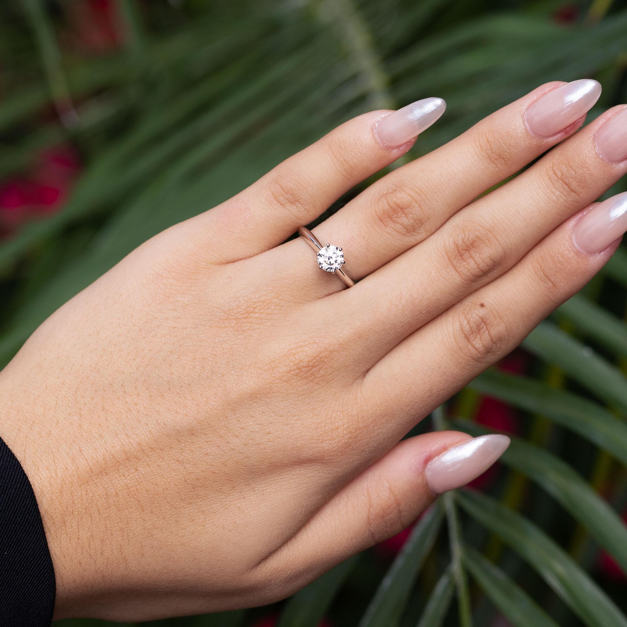 A vintage signed Tiffany & Co. solitaire ring, centered with a sustainably mined natural round brilliant diamond, set into a classic six prong setting. It features a near-flawless 3/4 carat fiery round diamond with scintillating sparkles set in a