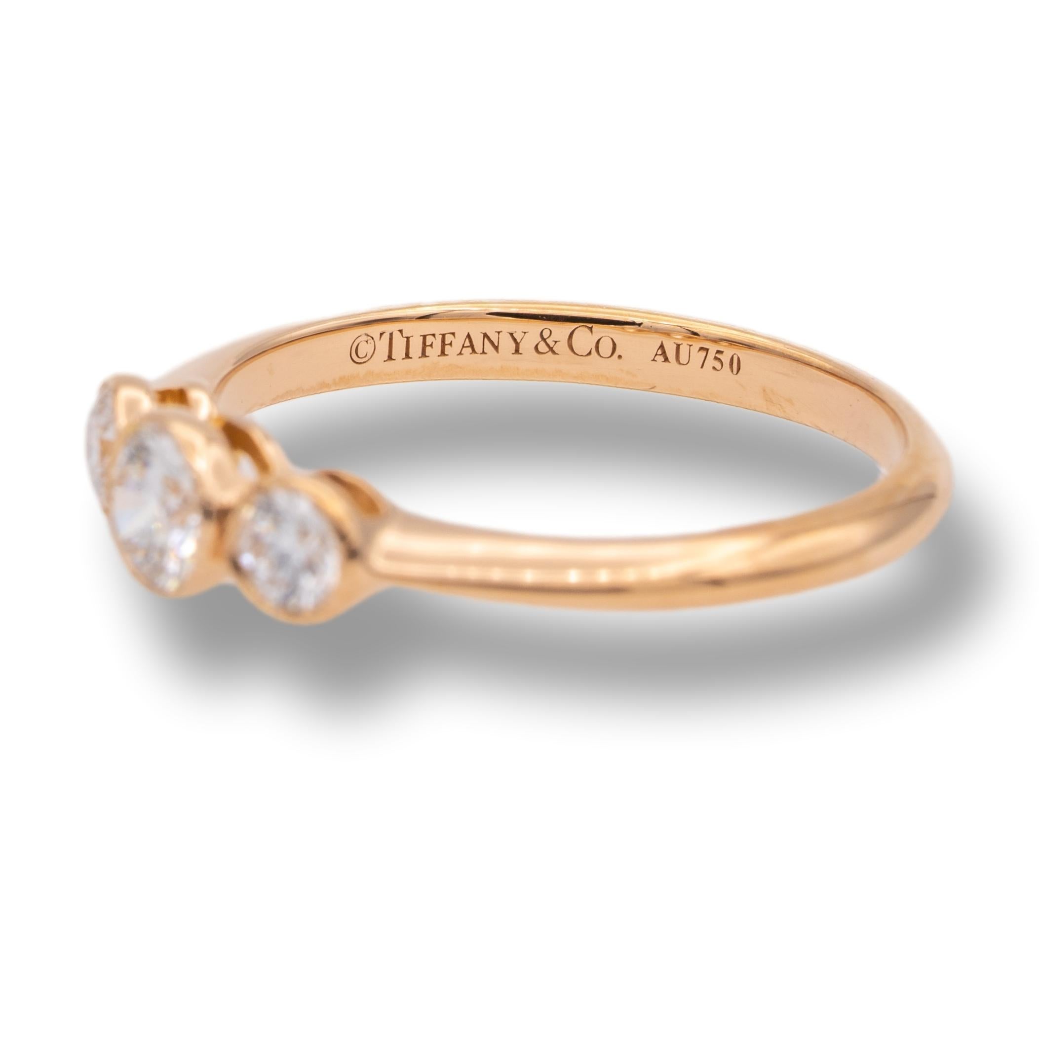 Tiffany & Co. 3 stone ring finely crafted in 18 karat rose gold with 3 round brilliant cut diamonds set in bezels with mill-grain edges. The diamonds weigh a total of 0.29 carats total weight, G color VVS2 clarity.

 

Brand: Tiffany &