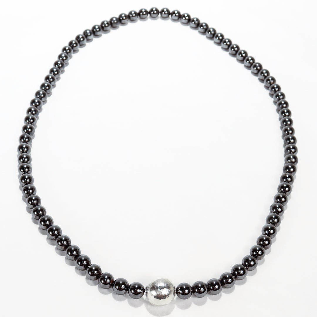 Collier en perles d'hématite et d'argent.

Par Tiffany & Co.

Conçu par Paloma Picasso.

Avec des perles d'hématite de 10 mm centrées sur une grande perle d'argent martelée à la main.

Avec son sac d'origine.

Un collier tout simplement magnifique