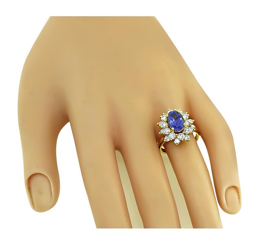 This is a fabulous 18k yellow gold ring by Tiffany & Co. The ring is centered with a lovely oval cut tanzanite that weighs approximately 3.00ct. The center stone is accentuated by sparkling round cut diamonds that weigh approximately 1.40ct. The