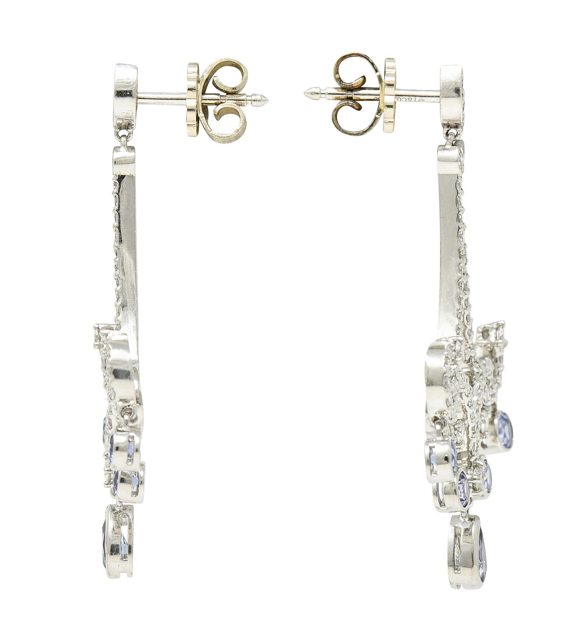 Drop earrings have an articulated navette surmount suspending an ornately scrolled drop

Set throughout by round brilliant cut diamonds weighing in total approximately 1.50 carats - G/H color with SI clarity

With articulated droplets of round and