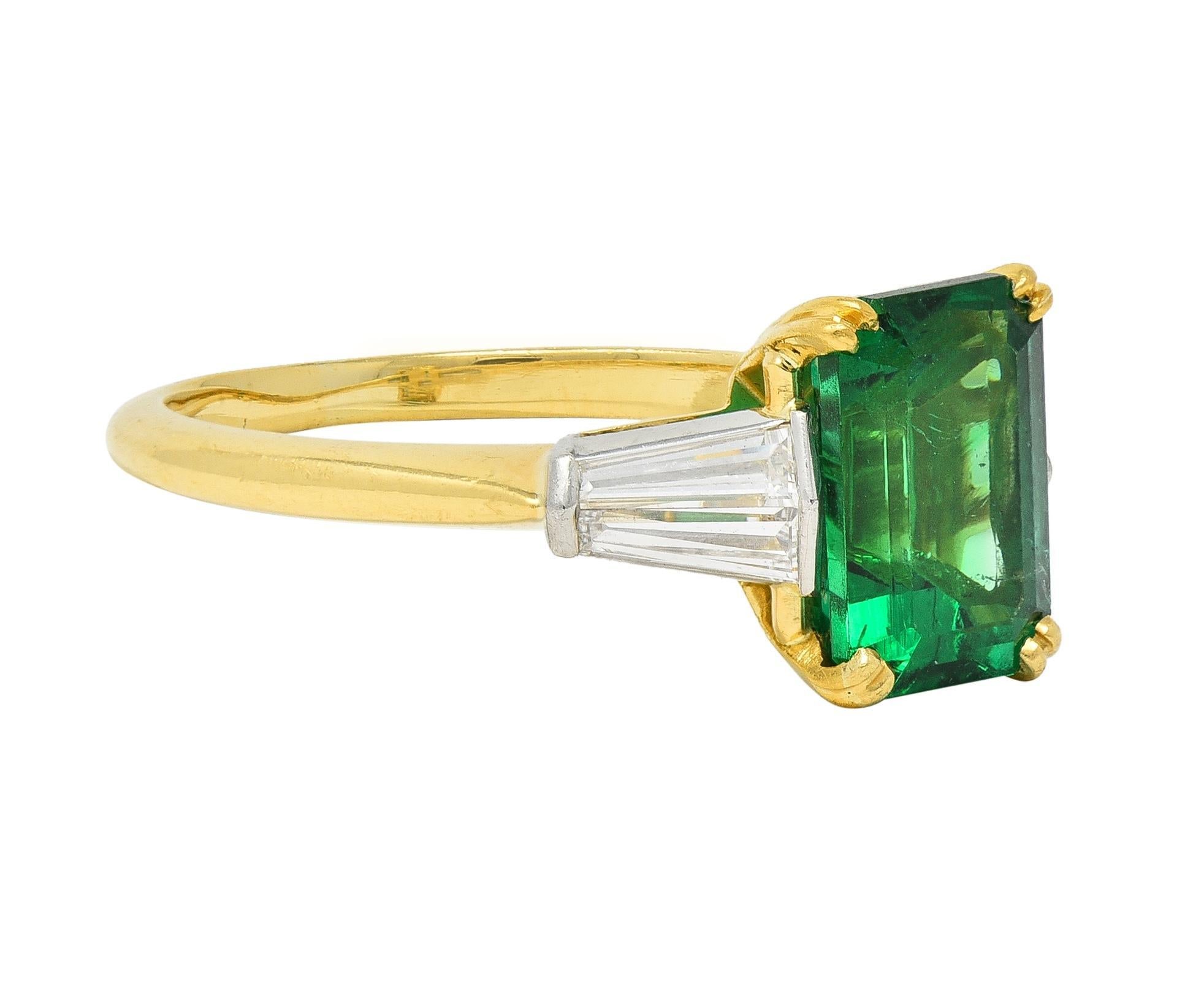 Centering an emerald cut emerald weighing approximately 2.55 carats - transparent medium green
Natural Zambian in origin with minor to insignificant traditional clarity enhancement
Set with split talon prongs in a gold basket and flanked by