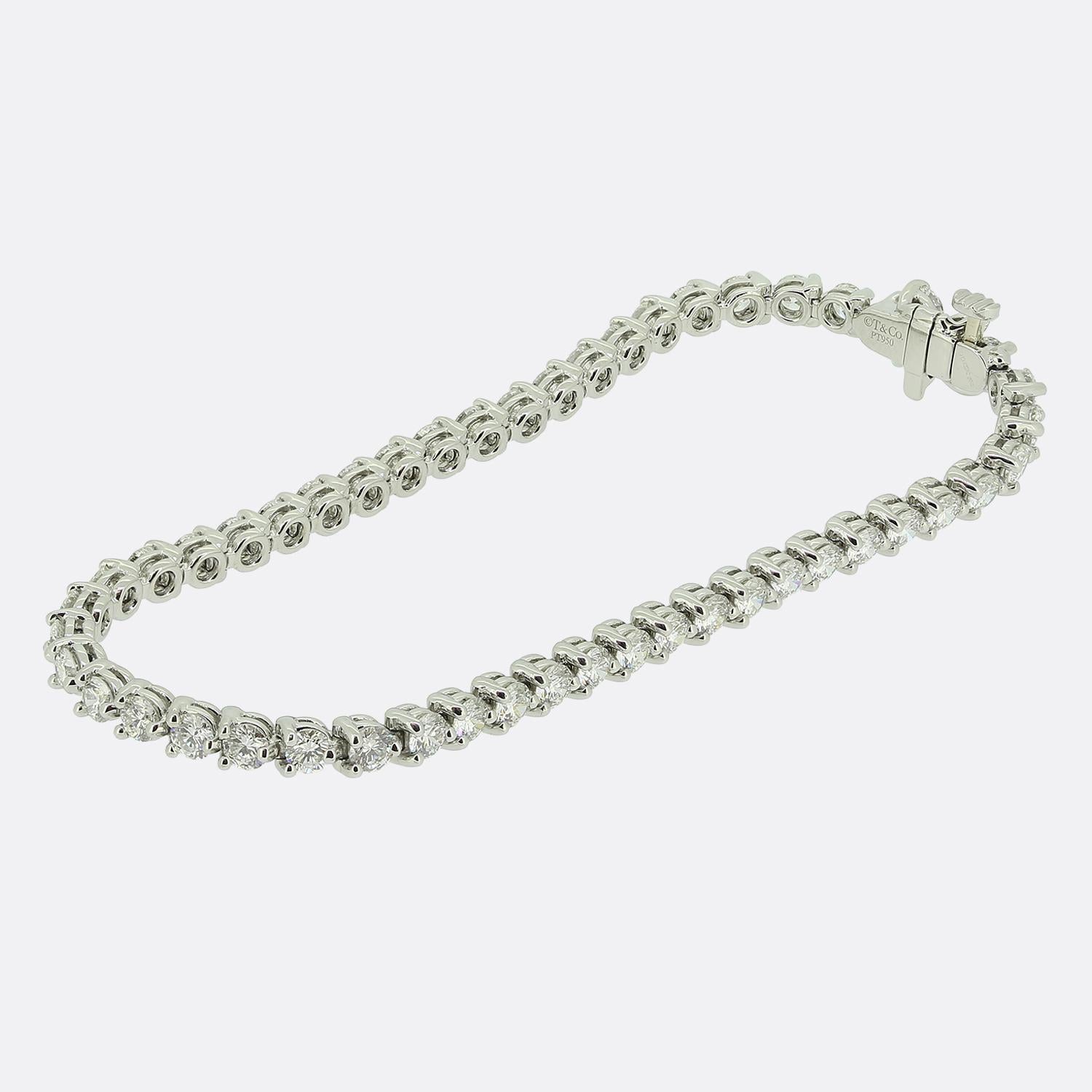 Here we have a refined platinum bracelet from the world renowned jewellery designer, Tiffany & Co. This piece forms part of the Victoria collection and features a continuous line of bright white round brilliant-cut diamonds, elegantly complemented
