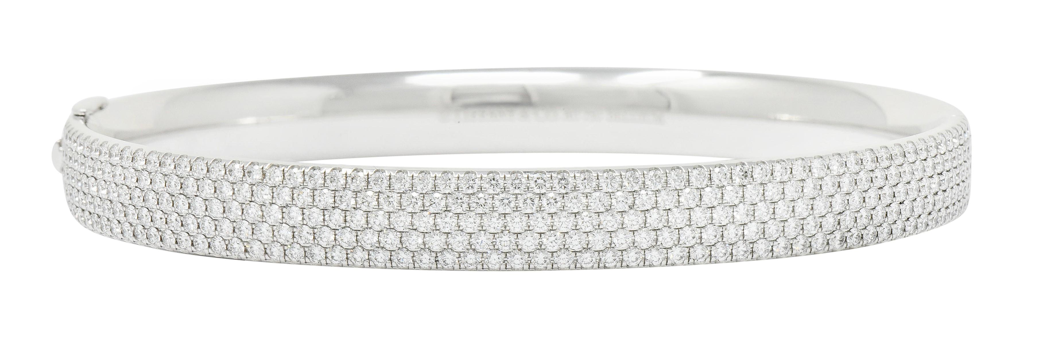 Hinged bangle bracelet features five rows of round brilliant cut melee diamonds

Pavè set to front and weighing approximately 4.96 carats; F/G color and VS clarity

Completes as a concealed clasp with a fold-over safety

Stamped Au750 for 18 karat