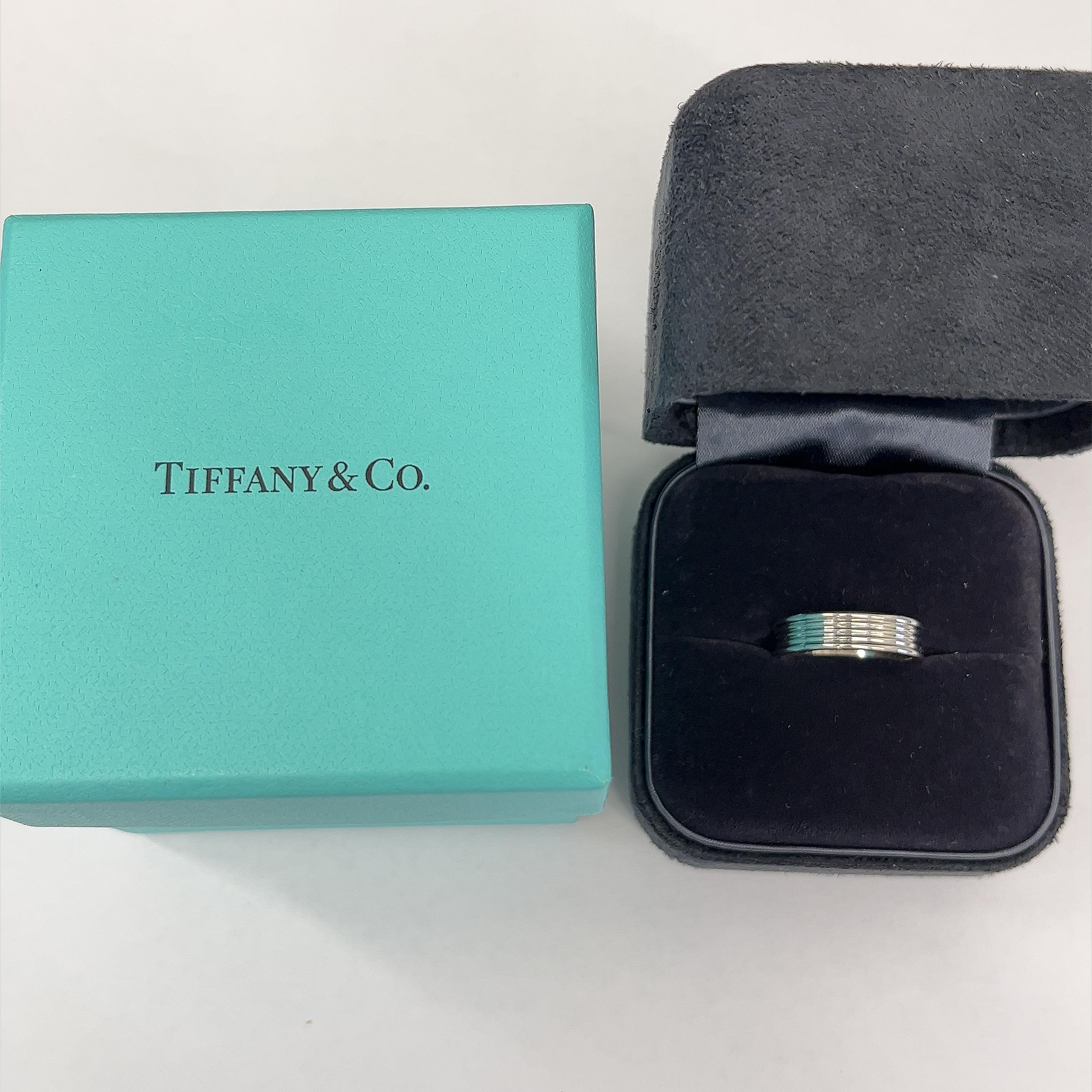 Embrace sophistication with the Tiffany & Co. 5 Row Band Ring in platinum. This stunning piece features five rows of sleek metal, meticulously crafted to create a timeless and versatile accessory. With its luxurious design and enduring elegance,