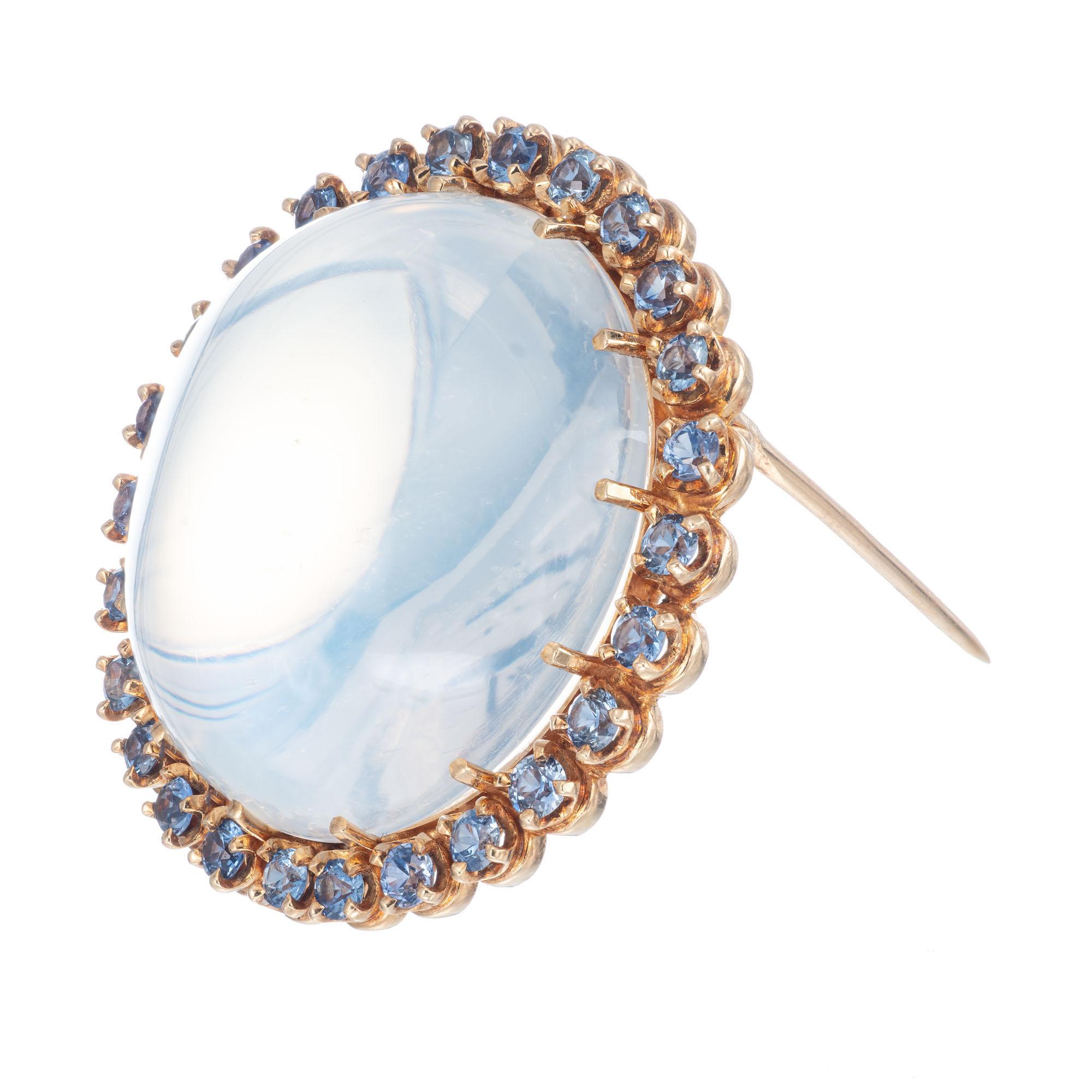 Tiffany & Co. Circa 1930's GIA certified moonstone with a halo of round violet sapphires in 14k yellow gold.

1 round double cabochon near colorless Moonstone SI, approx. 50.00cts GIA Certificate # 2205170421
26 round violet blue sapphires SI,