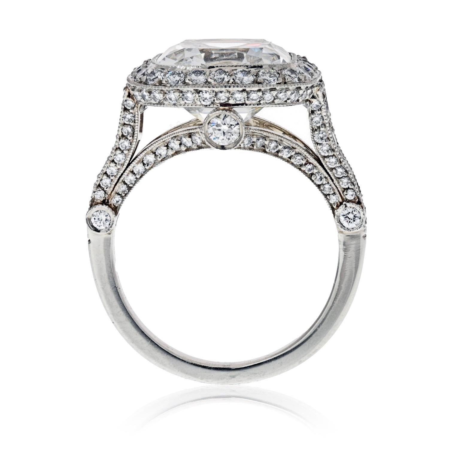Legacy diamond engagement ring, centering on a cushion-cut diamond weighing 5.56 carats, with a pave diamond surround and basket, as well as five graduated round-cut diamonds at either shoulder and six larger round-cut profile diamonds, the 134