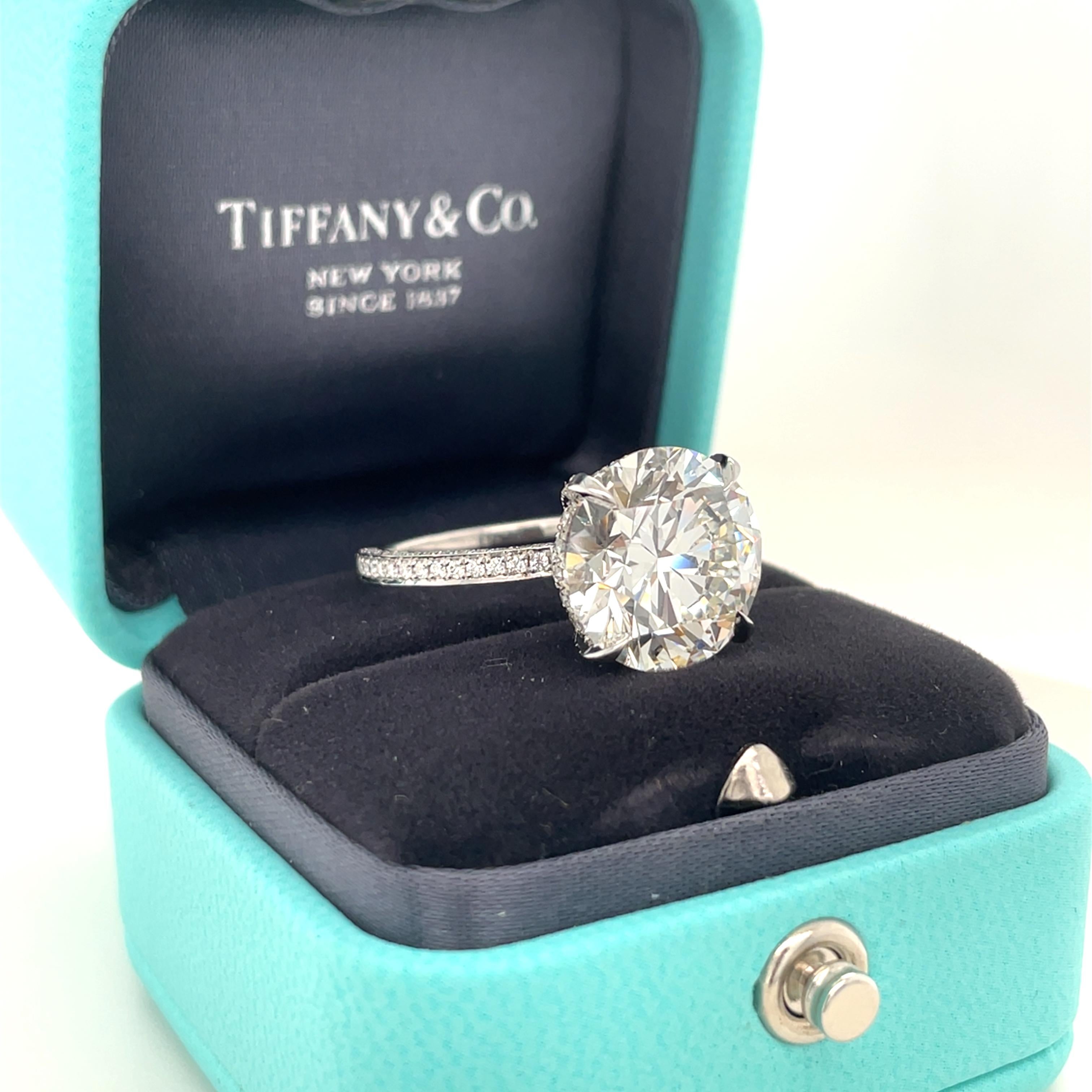 This beautiful engagement ring crafted by Tiffany & Co. boasts a center round brilliant cut diamond weighing 7.02 carats with I color, VS2 clarity and Triple Excellent cut, polish and symmetry. The shank and gallery encrusted with round brilliant