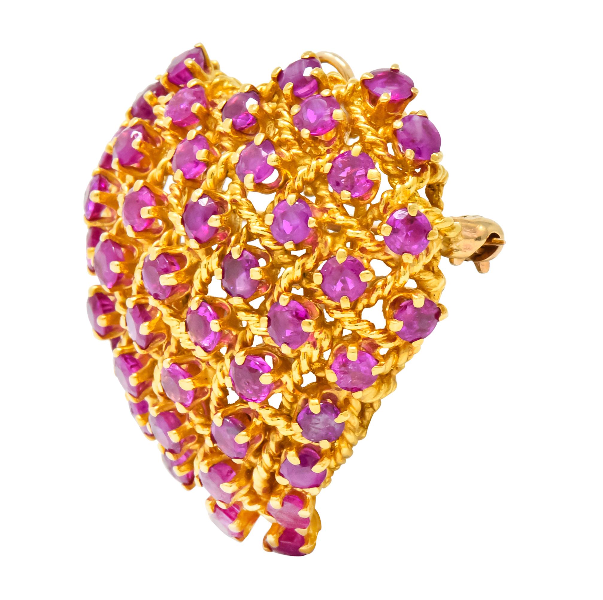 Brooch designed as pierced heart featuring a grid motif comprised of twisted cable 

Prong set throughout with round cut rubies weighing approximately 8.00 carats total, translucent raspberry red and very well matched 

Completed by 14 karat gold