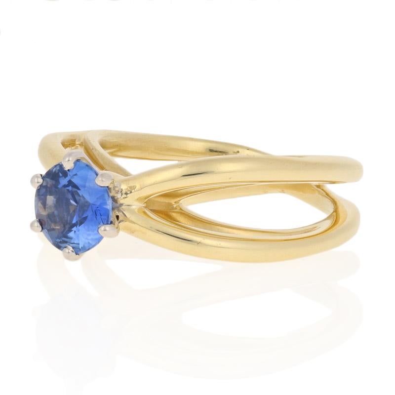 Designer beauty meets sculptural style in this wearable work of art! Crafted in 18k yellow gold, this Tiffany & Co. ring showcases a mirrored open cut design that creates a cathedral-style bridge which leads the eye up to a silky blue sapphire set