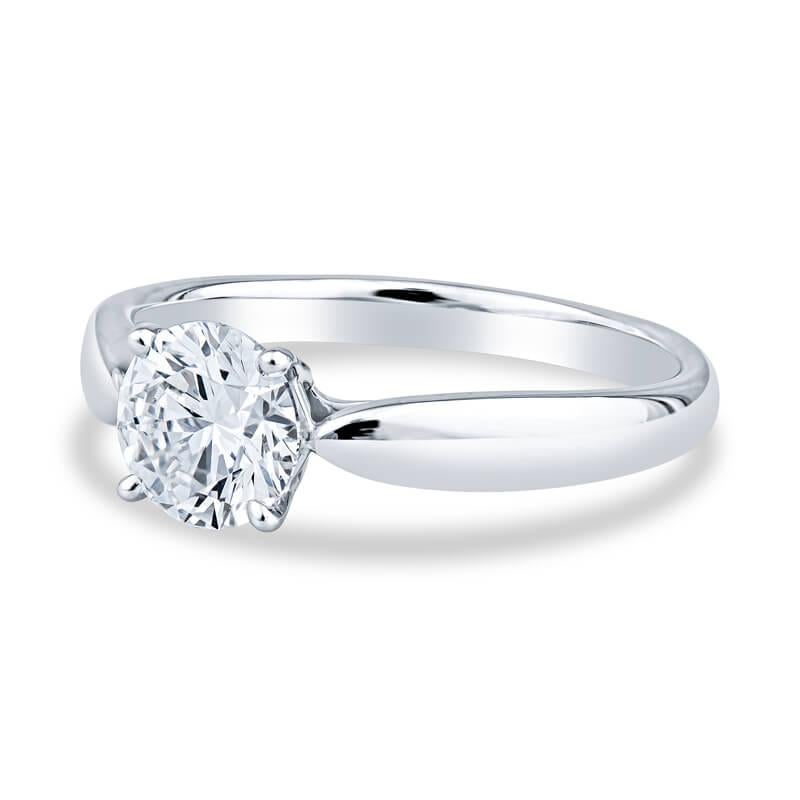 A very beautiful engagement ring featuring a .88ctw round brilliant cut diamond set in a platinum four pronged setting and tapered band. This delicate setting and tapered band allows the diamond to shine above the band. The diamond is G color and