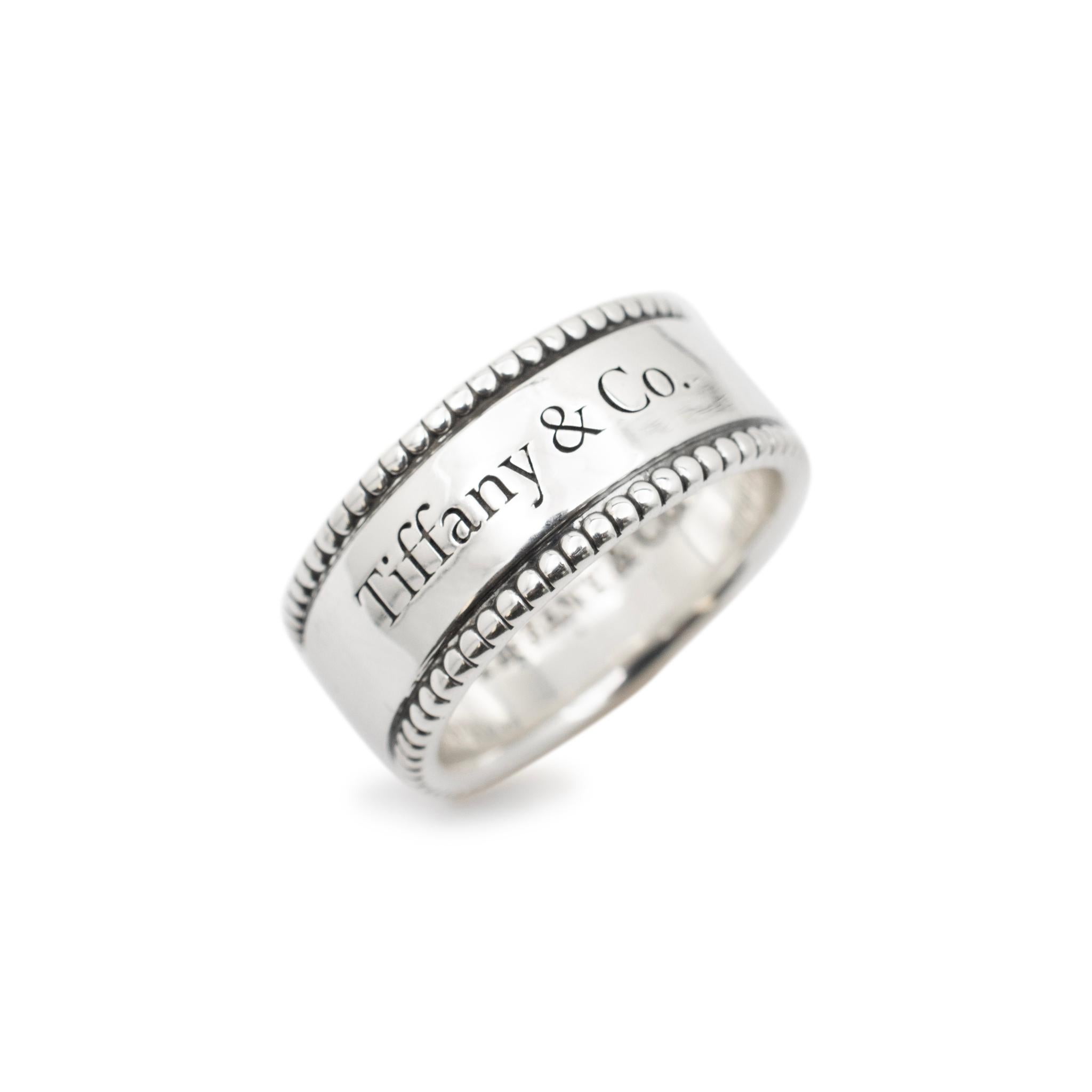 Brand: Tiffany & Co.

Gender: Ladies

Metal Type: Sterling Silver

Size: 4.5

Shank Maximum Width: 7.80 mm

Diameter: 19.10 mm

Weight: 6.80 grams

Ladies silver wedding ring. Engraved with 