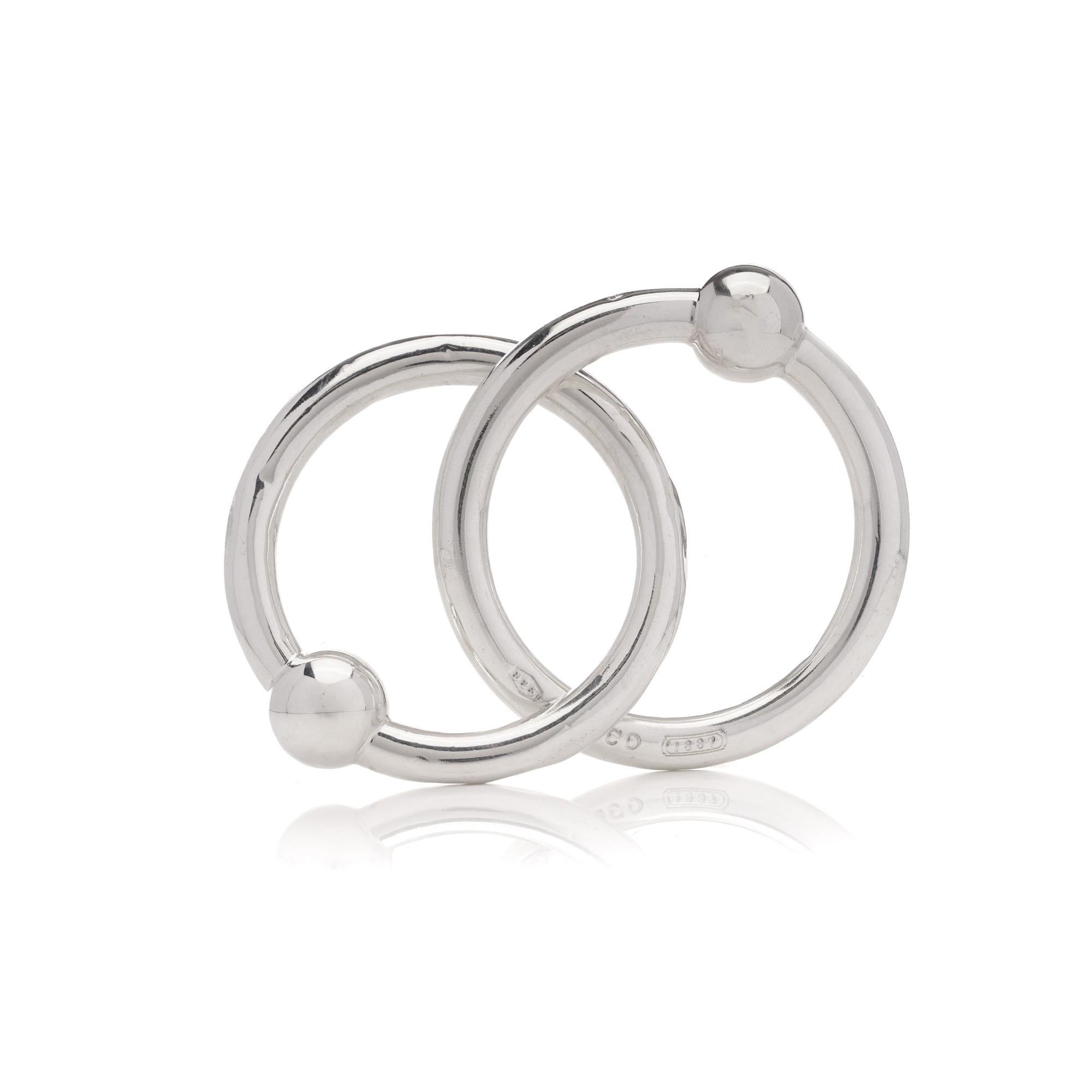 Tiffany & Co. 925 Sterling Silver Double Circle Baby Rattle. 
This elegant baby rattle by Tiffany & Co. is crafted from 925 sterling silver and features double circles. Hallmarked with T& Co. 1837 and 925, it reflects the brand's timeless design and