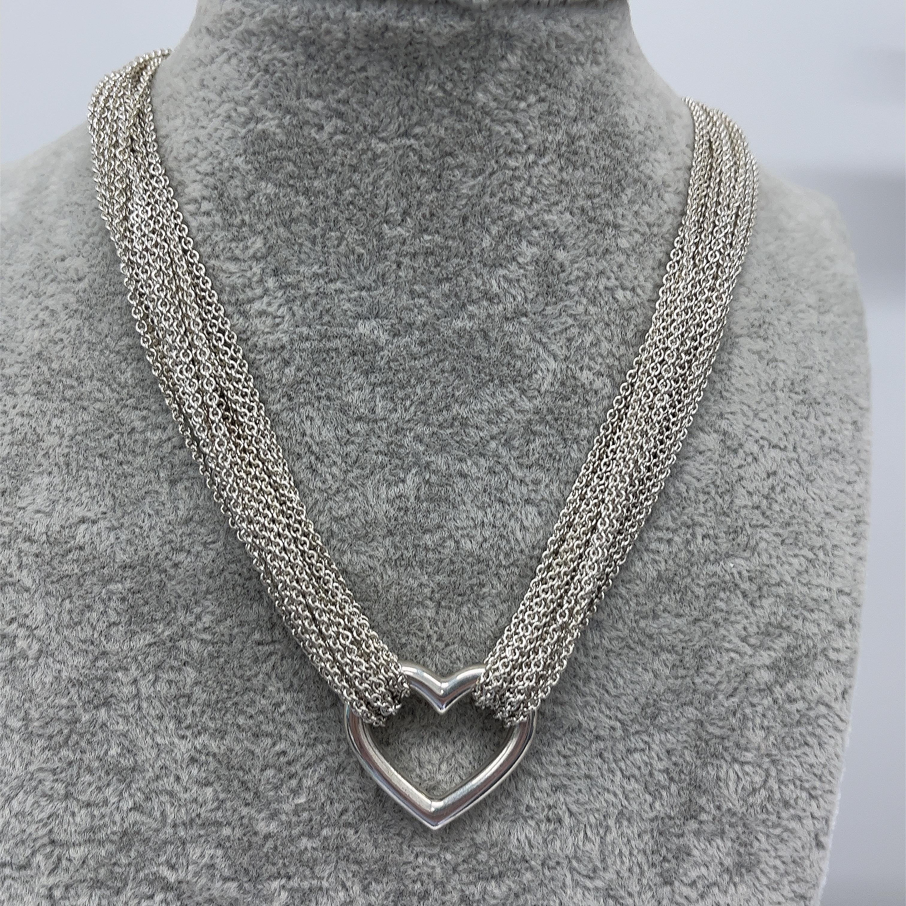 La collana con alamari a più fili in argento 925 di Tiffany & Co. è un accessorio versatile che emana raffinatezza e classe.
Il design a più fili di questa collana aggiunge profondità e dimensione alla tua scollatura. Le ciocche sono delicatamente