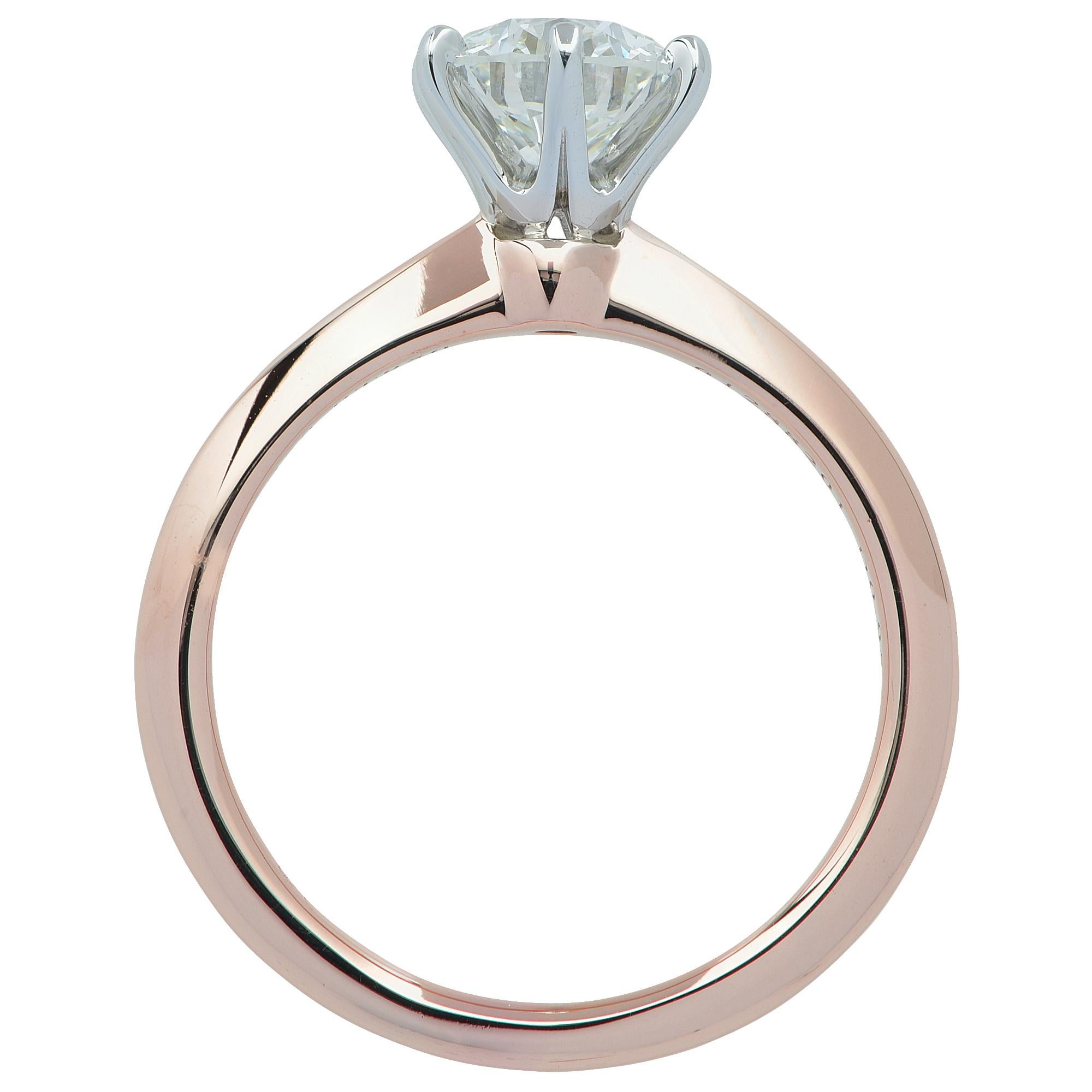 Elegant and timeless Tiffany & Co. engagement ring crafted in platinum and 18 karat rose gold featuring a .95 carat round brilliant cut diamond H color, VS1 clarity. This classic Tiffany & Co. ring is accompanied by original Tiffany & Co. paper work