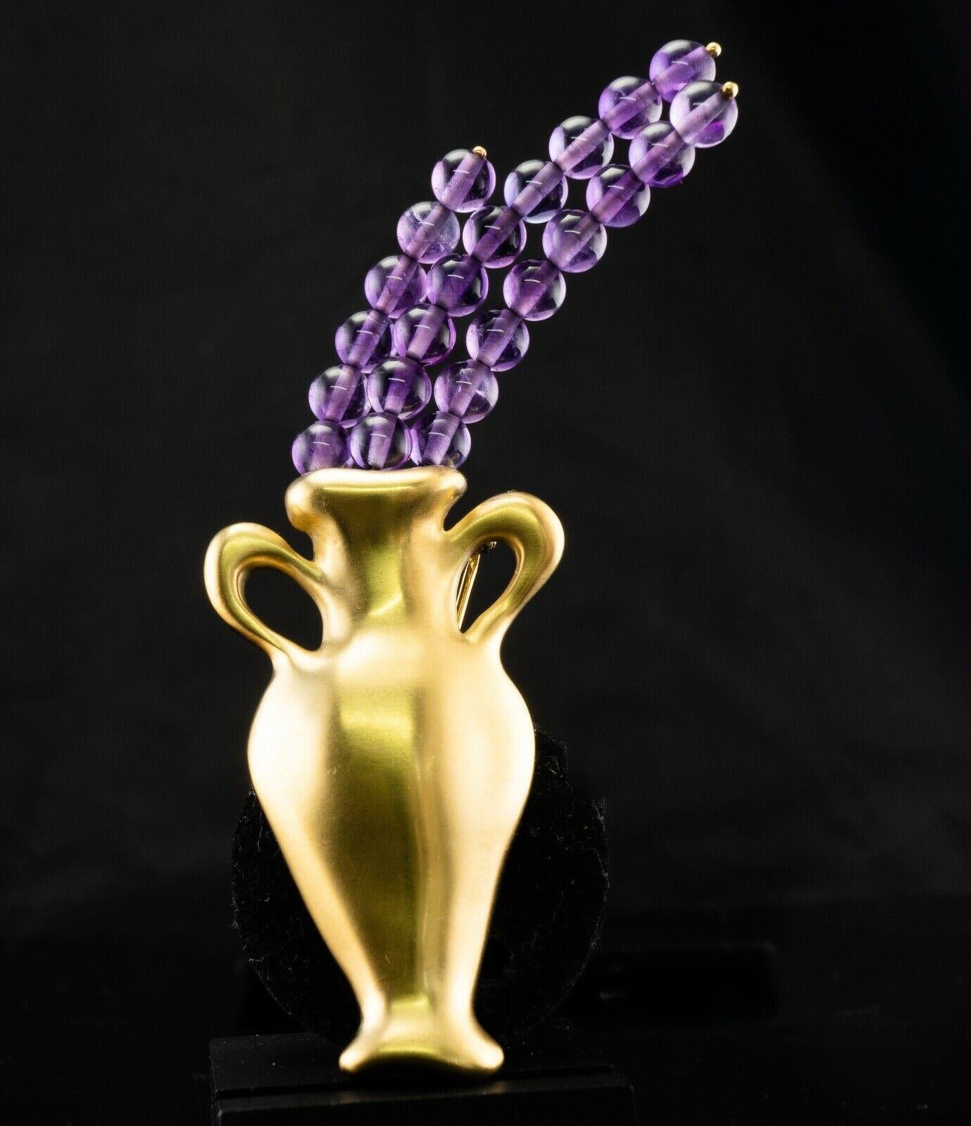 This authentic Tiffany & Co brooch is finely crafted in solid 18K Yellow Gold in the shape of a vase. Rare and unique, highly collectible. Twenty three natural Earth mined Amethyst beads measure 5mm each. These gems of a high quality are very clean