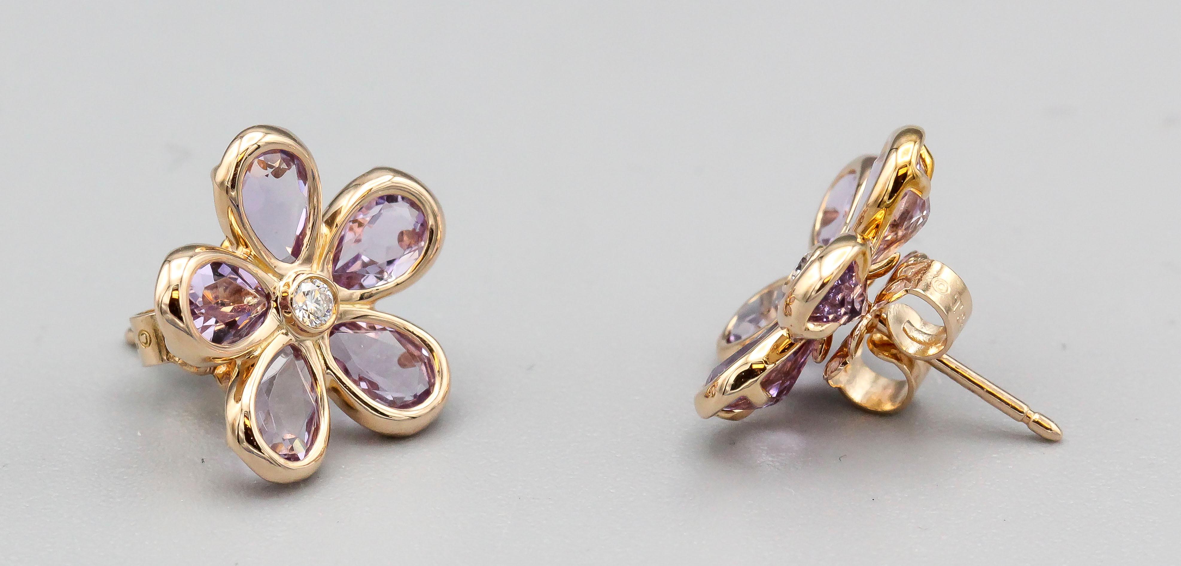 Fine amethyst, diamond and 18K yellow gold earrings by Tiffany & Co. They feature high grade pear shaped amethyst petals surrounding a round brilliant cut diamond at the center of an open flower design.  A charming pair of earrings for all