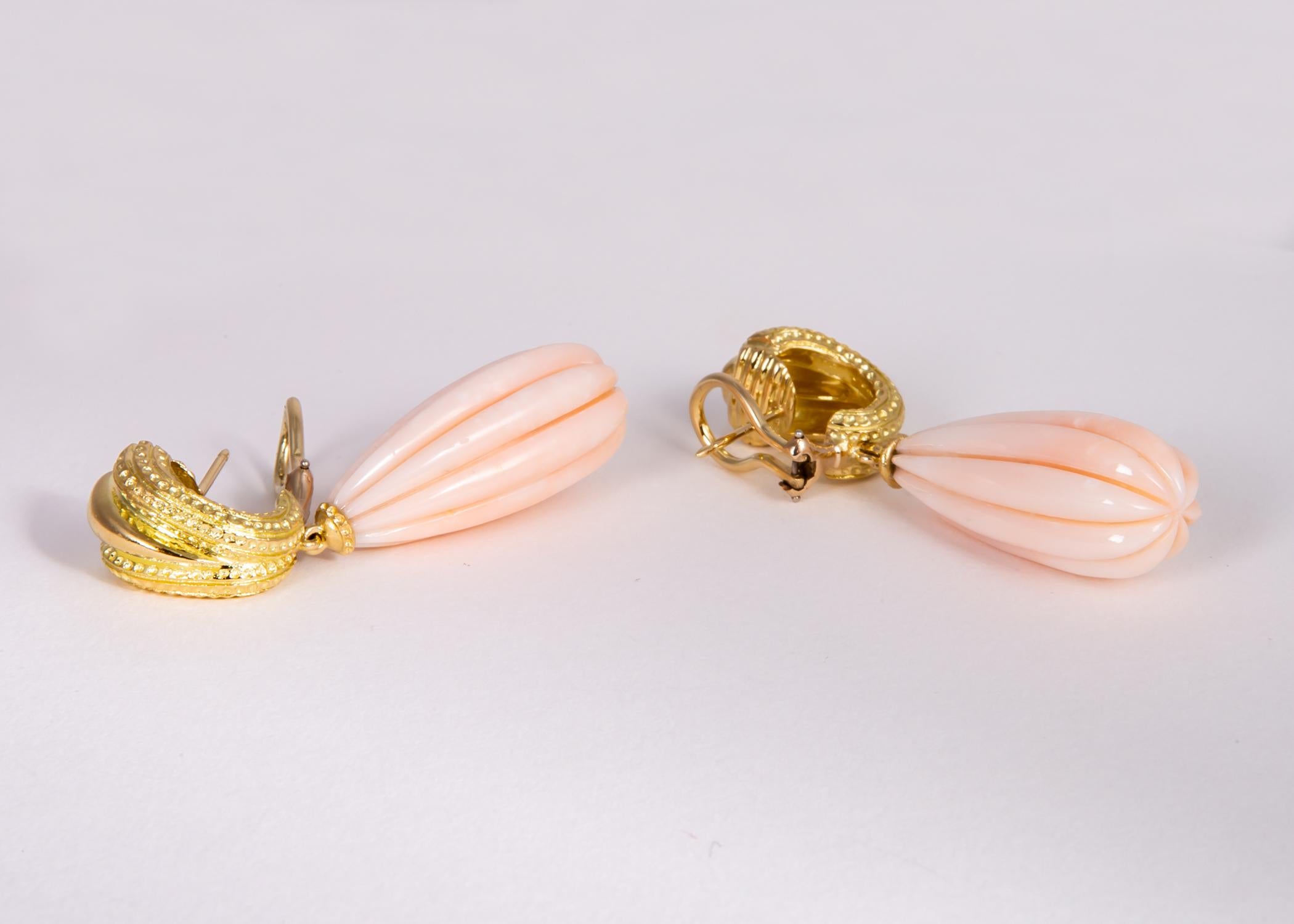 This elegant pair of vintage Tiffany & Co. earrings feature a pair of fluted angel skin coral with rarely seen completely even tone coloration. 2 inches in length.