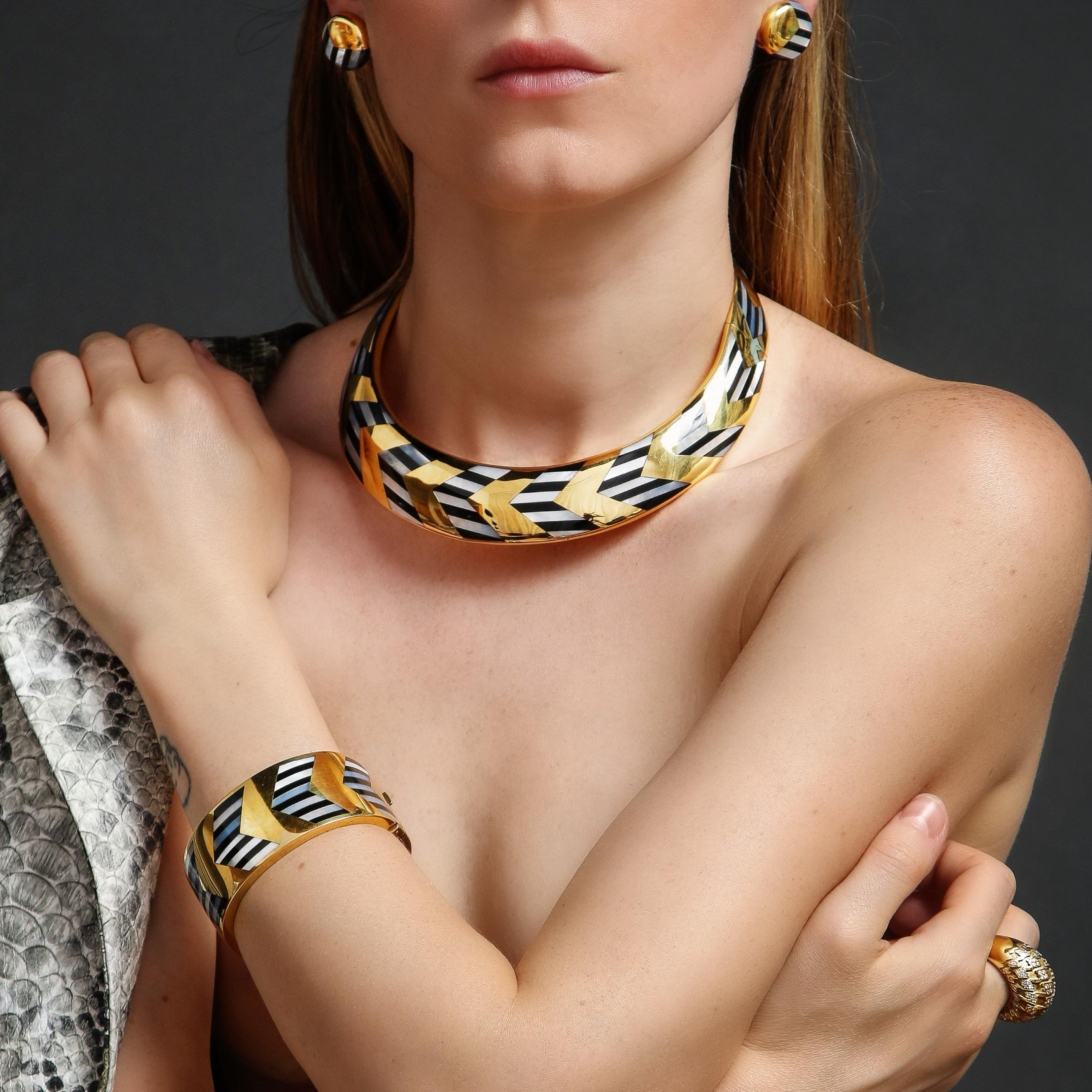 Ein atemberaubendes Design von Angela Cummings für Tiffany & Co. aus 18-karätigem Gold, bestehend aus einer Halskette, einem Armband und Ohrclips, die mit geometrischen Mustern aus schwarzer Jade und Perlmutt eingelegt sind. 
Die Halskette wiegt