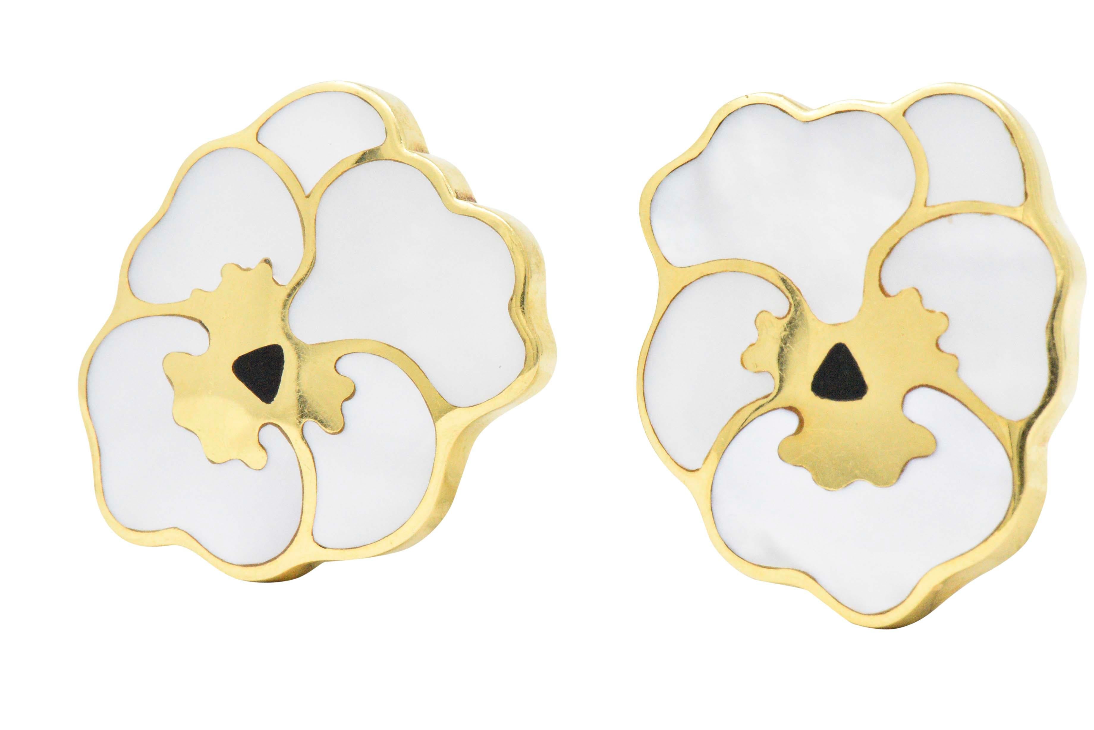Designed as pansies with inlaid mother-of-pearl petals 

With an onyx pistil and high polished gold throughout

Designed by Angela Cummings

Signed T & Co

With hinged omega backs and later added post findings

Measuring: Approx. 1 3/8 x 1 1/8